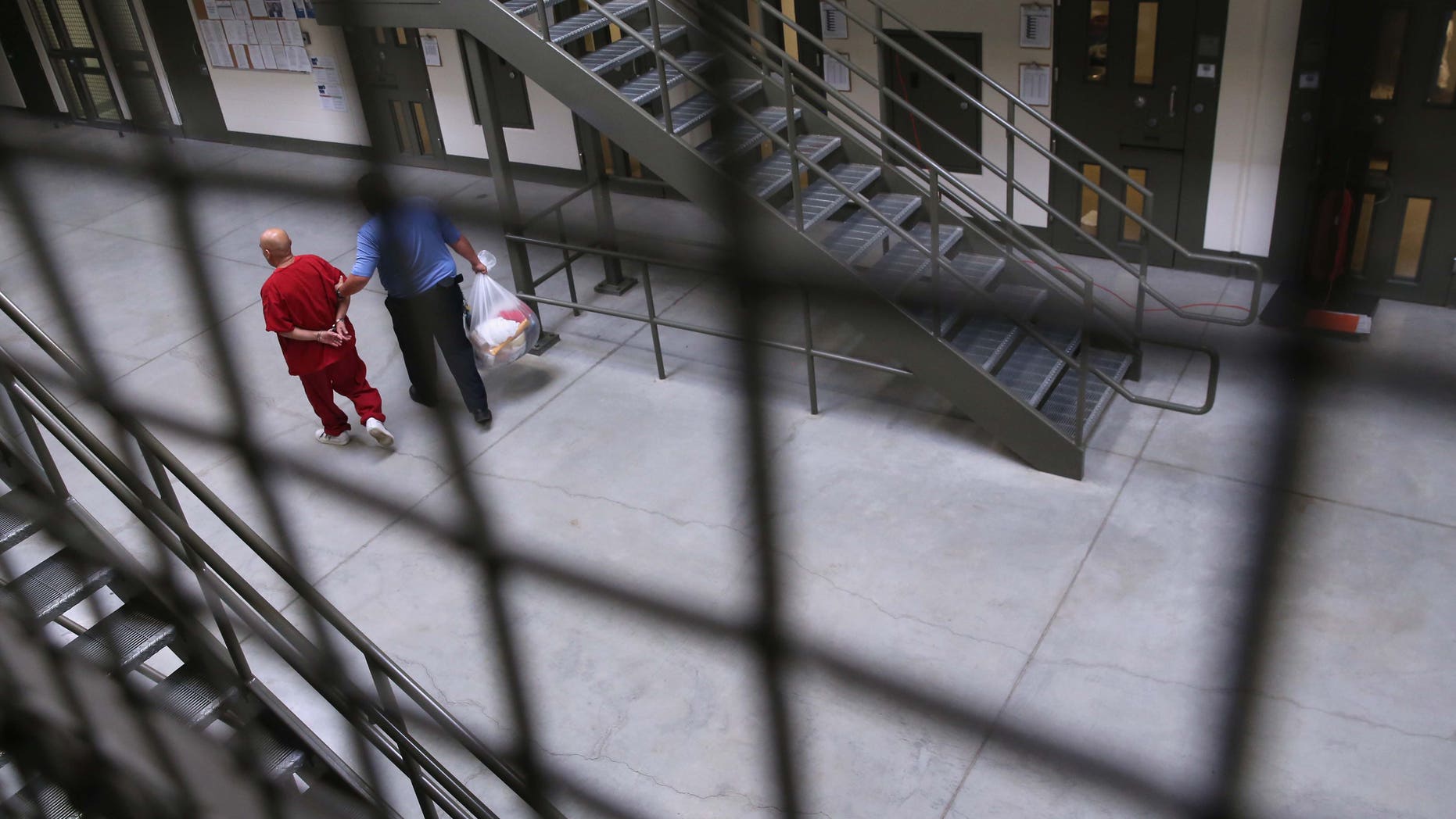 A guard escorts an immigrant detainee from his cell back into the general population at the Adelanto Detention Facility on November 15, 2013 in Adelanto, California. (Photo by John Moore/Getty Images)