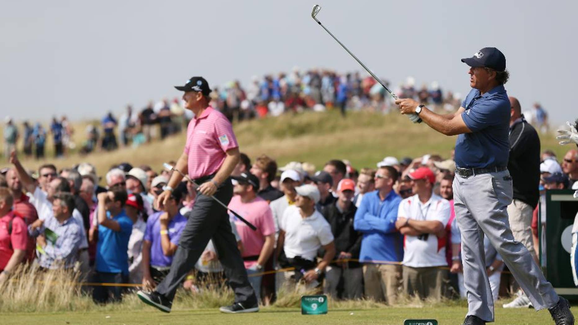 Phil Mickelson of the US plays his shot off the 9th tee box as Ernie Els of South Africa starts to walk along the fairway during the second day of the British Open Golf championship at the Royal Liverpool golf club, Hoylake, England, Friday July 18, 2014. (AP Photo/Scott Heppell)