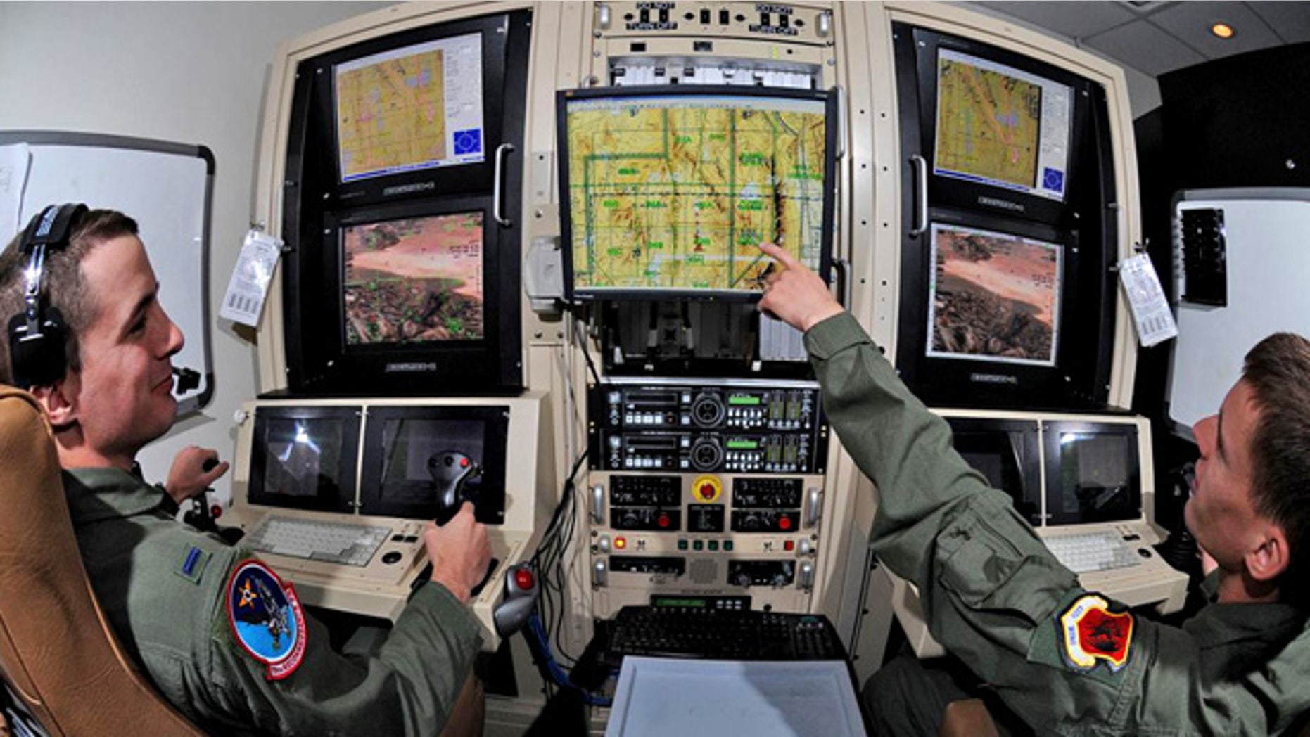 Airman 1st Class Caleb Force assists 1st Lt. Jorden Smith, a MQ-1B Predator pilot, in locating simulated targets during a training mission conducted inside the simulators at Creech Air Force Base, Nev.