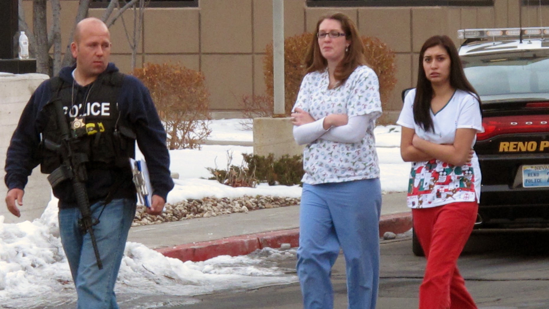 Police escort hospital staff away from a medical office building in Reno, Nev., on Tuesday, Dec. 17, 2013. A suicidal gunman killed one person and critically wounded two others before turning the gun on himself on the grounds of Renown Regional Medical Center Tuesday. (AP Photo/Scott Sonner).