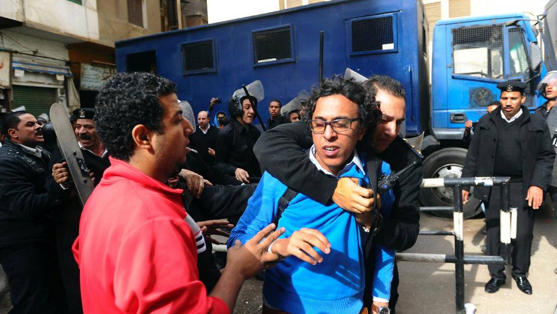 FILE - In this Nov. 30, 2013 file photo, a protester is detained near a Cairo court where supporters of the April 6 youth group gathered to condemn the detention of 24 activists arrested the previous week while taking part in a protest that was not authorized by authorities, in Cairo. Egypt. A defense lawyer said Tuesday, Jan. 27, 2015 that Egypt’s highest appeal court has upheld the convictions and three-year prison sentences handed down to Ahmed Maher, Ahmed Douma and Mohammed Adel, three of Egypt’s most prominent political activists for violating a draconian protest law. (AP Photo/Ahmed Omar, File)