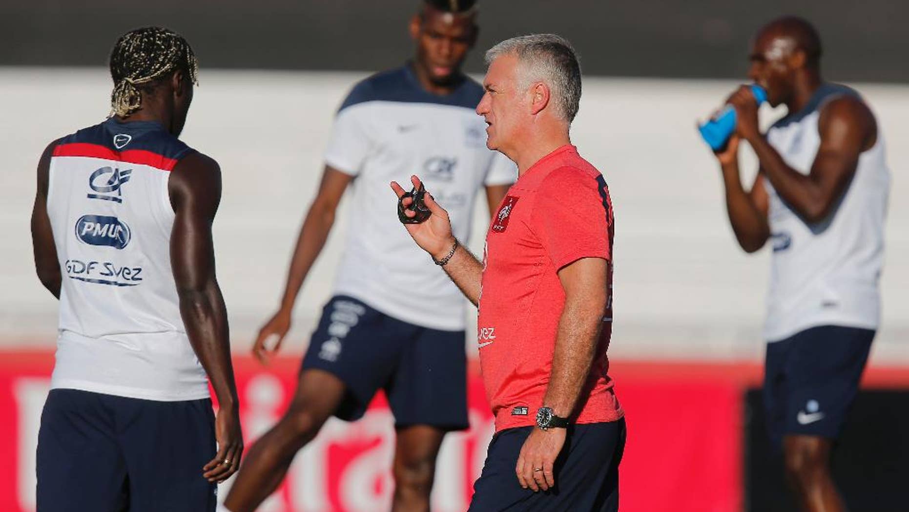France's head coach Didier Deschamps talks to his layers during a during a training session at the Santa Cruz stadium, in Ribeirao Preto, Brazil, Saturday, June 21, 2014. France faces Ecuador, Switzerland and Honduras in group E of the World Cup. Having captured people's attention at the soccer World Cup with some scintillating attacking football, France's players are now in unknown territory after raising expectations back home, having routed Switzerland and Honduras. (AP Photo/David Vincent)