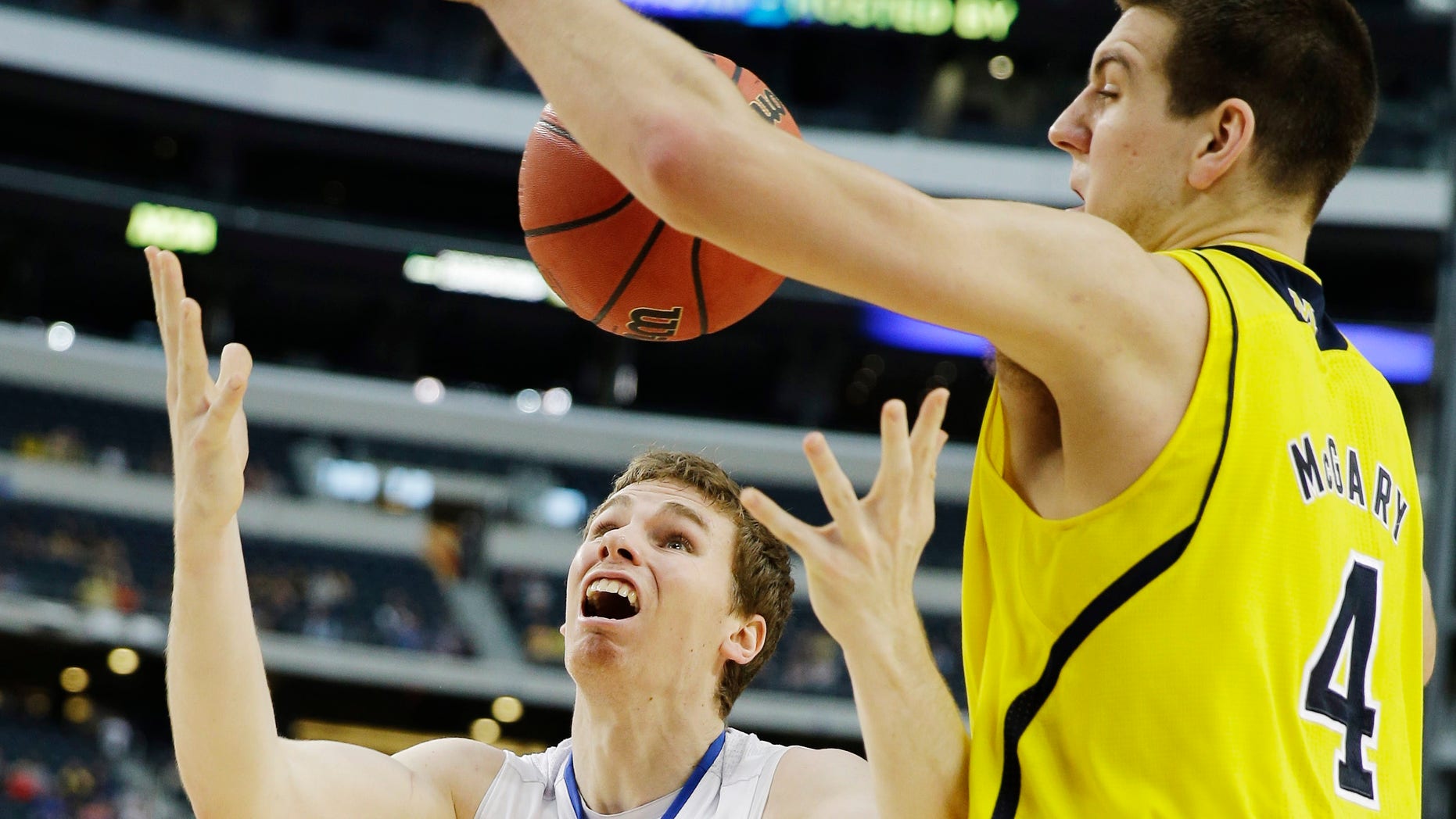 Michigan's Mitch McGary (4) knocks the ball away from Florida's Erik Murphy (33) during the first half of a regional final game in the NCAA college basketball tournament, Sunday, March 31, 2013, in Arlington, Texas. (AP Photo/David J. Phillip)