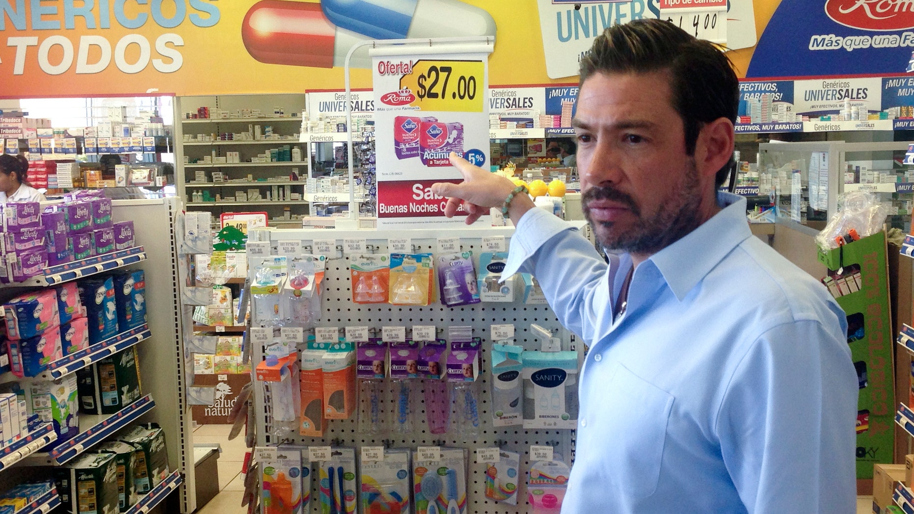 In this Jan. 27, 2015 image, Roberto Castro, chief executive officer of Farmacias Roma, gestures inside one of his locations in Tijuana, Mexico. Castro, who's customers often pay in dollars, faces tough challenges amid a clamor to crack down on money laundering. Many American banks, wary of the potential for massive penalties, have closed Mexican accounts or saddled customers with new restrictions rather than risk the chance. (AP Photo/ Elliot Spagat)