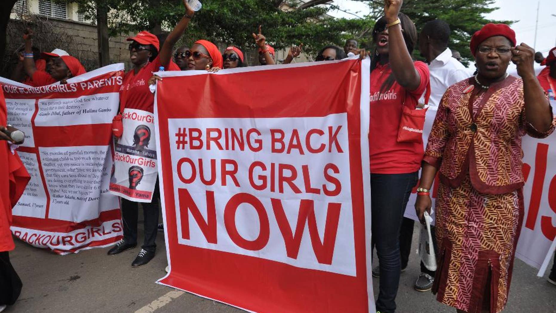 FILE - In this file photo taken Tuesday, Oct. 14, 2014, people demonstrate calling on the Nigerian government to rescue girls taken from a secondary school in Chibok region, in the city of Abuja, Nigeria. There is cautious optimism in Nigeria, Monday, Oct. 20, 2014 over local reports that the more than 200 abducted Nigerian schoolgirls may soon be released soon as part of a cease-fire agreement with the country’s Islamic rebels, Boko Haram. (AP Photo/Olamikan Gbemiga, File)