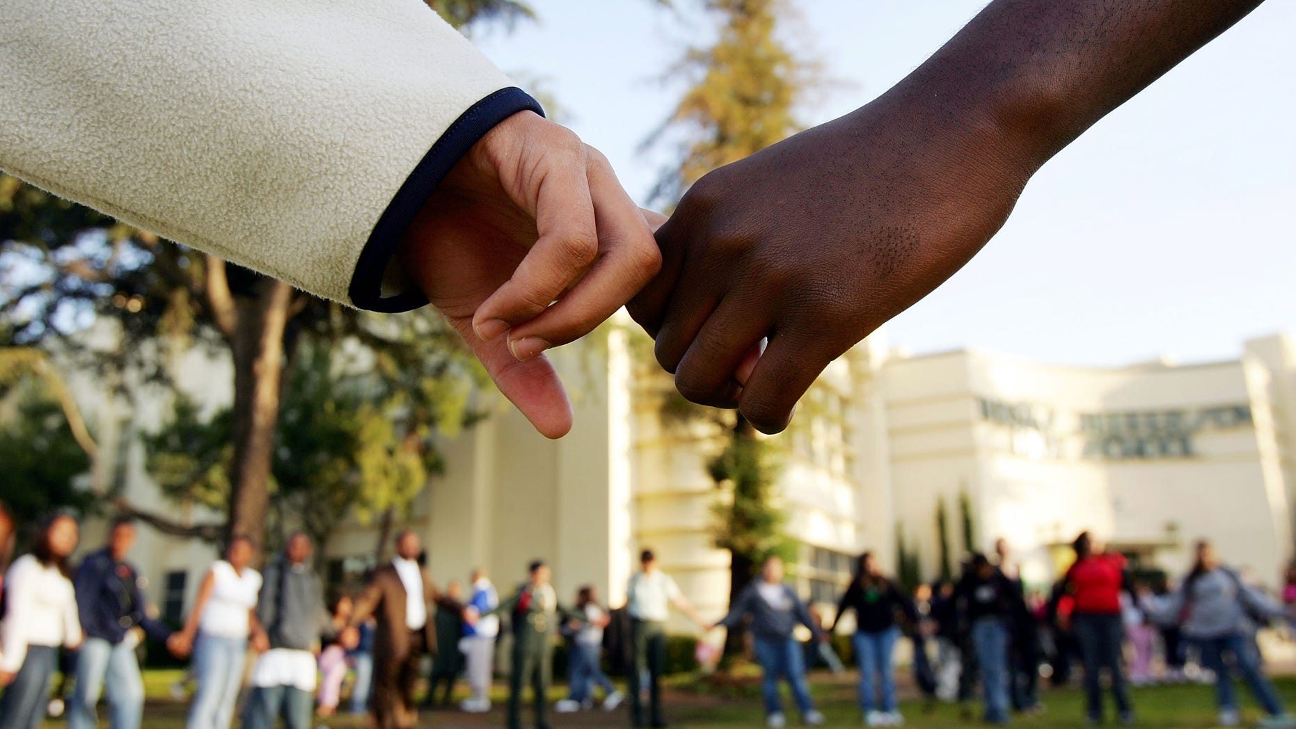 LOS ANGELES, CA - APRIL 21: Students pray in the aftermath of two apparent racially motivated student brawls at Thomas Jefferson High School April 21, 2005 in Los Angeles, California. A number of students suffered injuries this week while fleeing from a lunch period brawl involving about 200 Latino and African-American students, the second racially charged incident in less than a week. Stepped-up school police and Los Angeles police presence, strict regulation of clothing styles that could be associated with gangs, and a tightened school bell schedule that leaves little time to linger between classes are in effect to curb the violence. (Photo by David McNew/Getty Images)