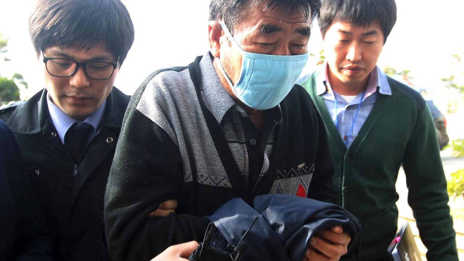 FILE - In this April 19, 2014 file photo, Lee Joon-seok, center, the captain of the sunken ferry boat Sewol in the water off the southern coast, arrives at the headquarters of a joint investigation team of prosecutors and police in Mokpo, south of Seoul, South Korea. A colleague calls Capt. Lee Joon-seok the nicest person on the ship. Yet there he was, captured in video on the day his ferry sank with hundreds trapped inside, being treated onshore after allegedly landing on one of the first rescue boats. (AP Photo/Yonhap, File) KOREA OUT