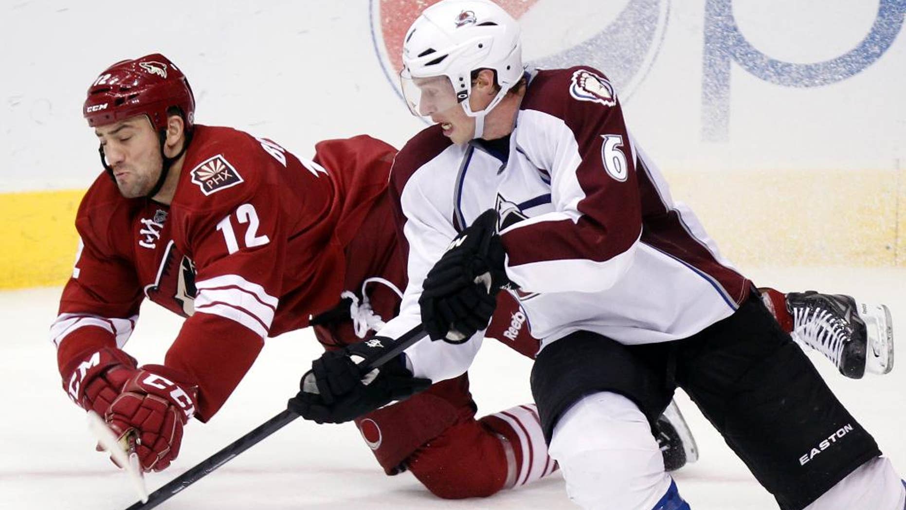 FILE - In this April 6, 2013, file photo, Phoenix Coyotes left winger Paul Bissonnette, left, and Colorado Avalanche defenseman Erik Johnson, right, compete for the puck in the third period of an NHL hockey game in Glendale, Ariz. Bissonnette’s fists and fingers have provided entertainment for hockey fans for years. He was at it again at the start of the NHL’s free agency period on Friday, July 1, 2016, having a little fun with his job search as it unfolded. (AP Photo/Paul Connors, File)