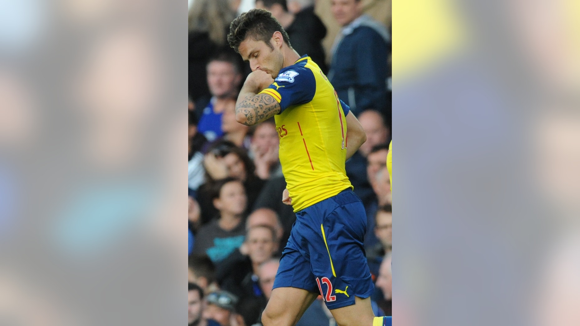 Arsenal's Olivier Giroud kisses his hand after scoring against Everton during the English Premier League soccer match between Everton and Arsenal at Goodison Park, in Liverpool, England, Saturday, Aug. 23, 2014. (AP Photo/Rui Vieira)