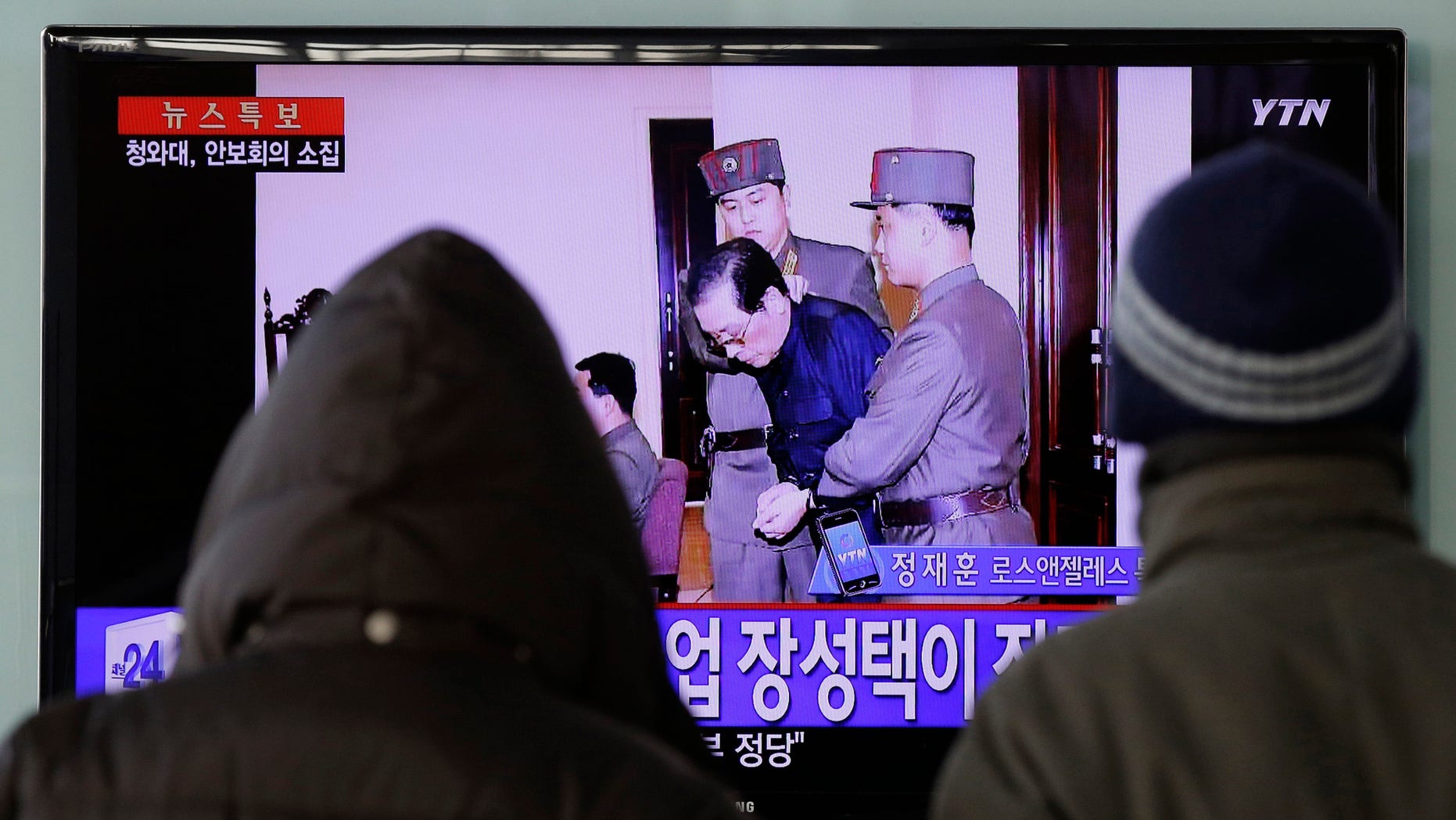 FILE - In this Dec. 12, 2013 file photo, people watch a TV news report about the execution of Jang Song Thaek, the uncle of North Korean leader Kim Jong Un, at Seoul Railway Station in Seoul, South Korea. The letters on the left top, read "North Korea Executed Jang Song Thaek after trial." The stunning execution of Kim Jong Un's powerful uncle strips China of its most important link to North Korea's leadership and deepens concerns over how the unruly neighbor will proceed on Beijing's key issues of nuclear disarmament and economic reform.(AP Photo/Lee Jin-man, File)