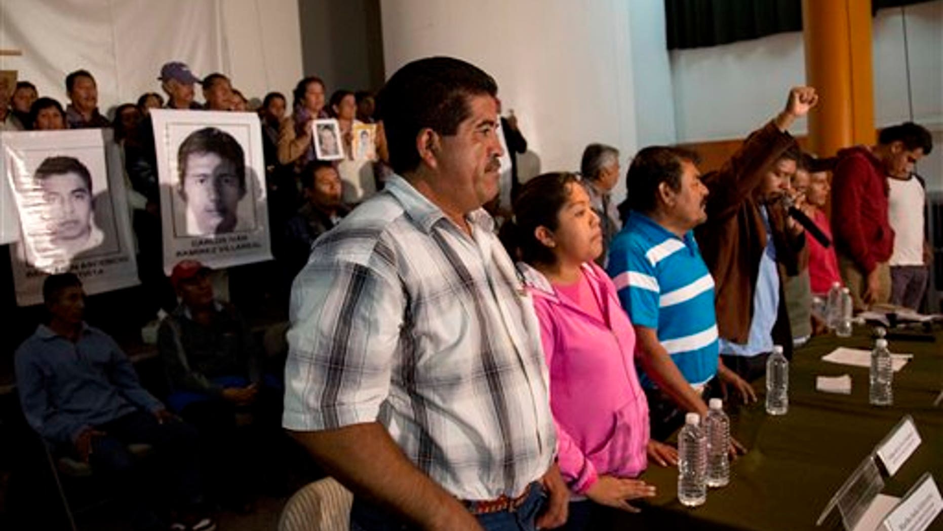 Parents of missing students, some holding pictures of the missing, attend the press conference after a meeting with Mexico's President Enrique Pena Nieto in Mexico, City, Wednesday Oct. 29, 2014. President Enrique Pena Nieto met with parents of 43 teachers college students Wednesday for the first time since they disappeared over a month ago, when investigators say police detained the students and handed them over to a drug gang. (AP Photo/Eduardo Verdugo)