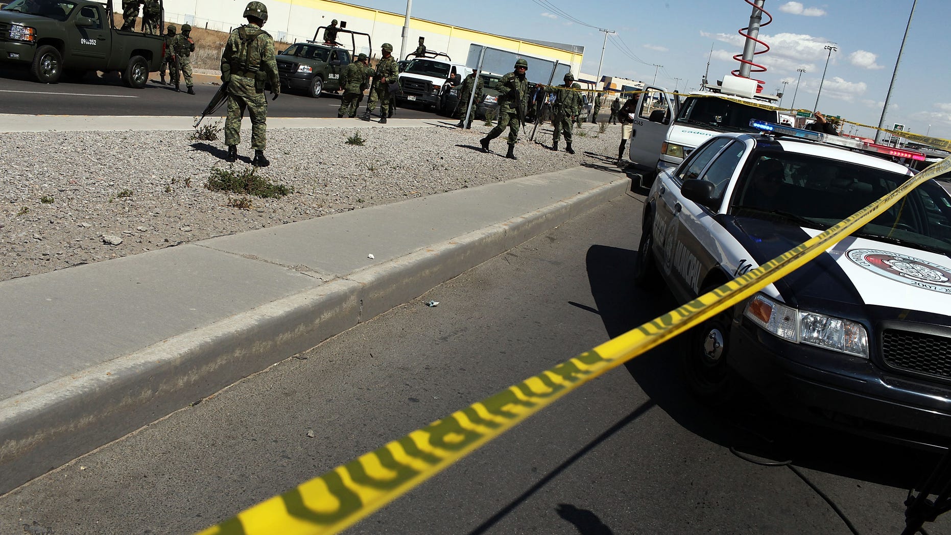 JUAREZ, MEXICO - MARCH 24: Military police keep guard at the site of a murder on March 24, 2010 in Juarez, Mexico. Secretary of State Hillary Rodham Clinton, Defense Secretary Robert Gates, and Homeland Security Secretary Janet Napolitano all visited Mexico yesterday for discussions centered on Mexico's endemic drug-related violence. The border city of Juarez, Mexico has been racked by violent drug-related crime recently and has quickly become one of the most dangerous cities in the world in which to live. As drug cartels have been fighting over ever-lucrative drug corridors along the United States border, the murder rate in Juarez has risen to 173 slayings for every 100,000 residents. President Felipe Calderon's strategy of sending 7000 troops to Juarez has not mitigated the situation. With a population of 1.3 million, 2,600 people died in drug-related violence last year and 500 so far this year, including two Americans recently who worked for the U.S. Consulate and were killed as they returned from a child's party. (Photo by Spencer Platt/Getty Images)