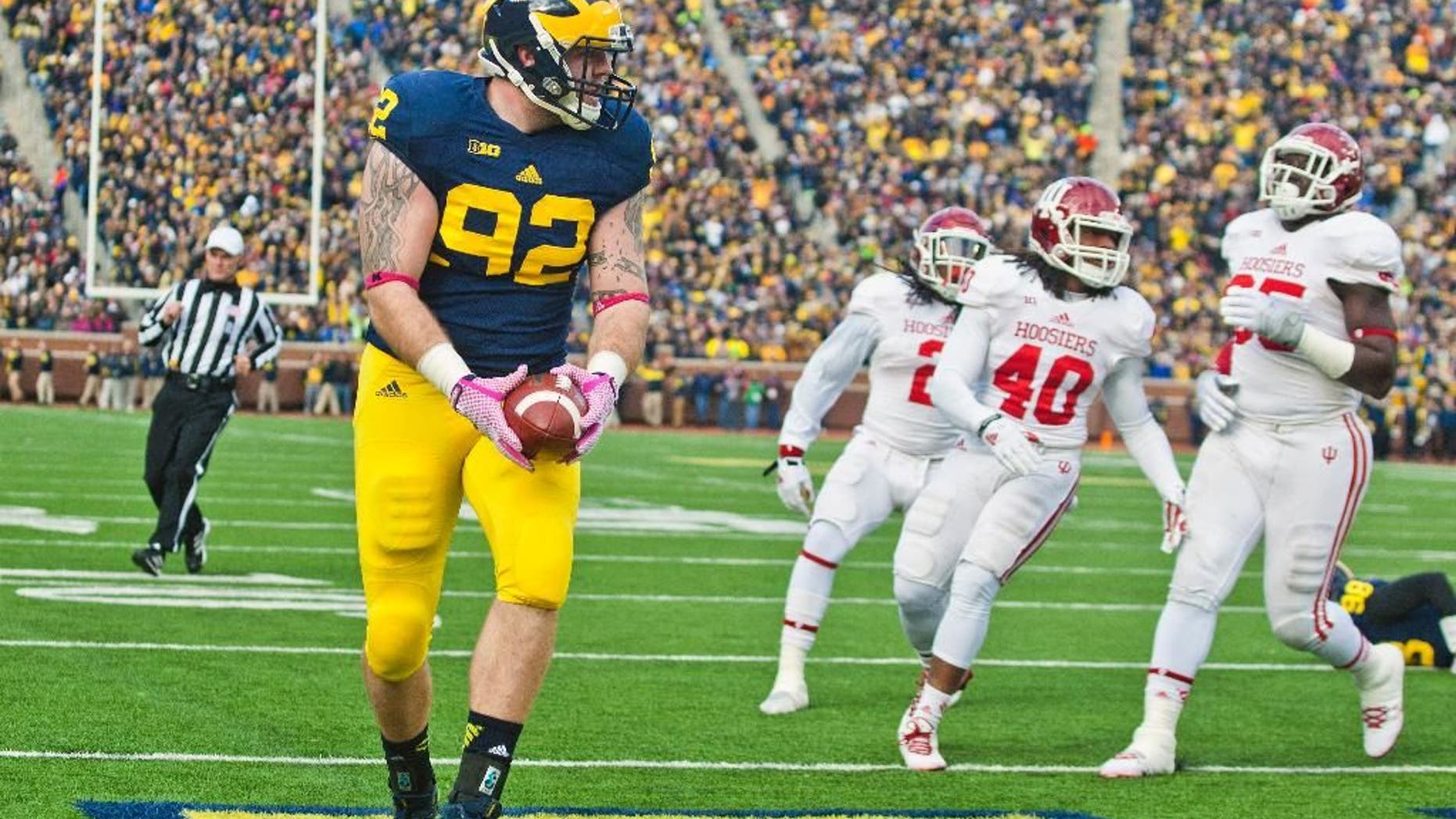 Indiana quarterback Zander Diamont (12) escapes a tackle while rushing with the ball in the third quarter of an NCAA college football game against Michigan in Ann Arbor, Mich., Saturday, Nov. 1, 2014. Michigan won 34-10. (AP Photo/Tony Ding)