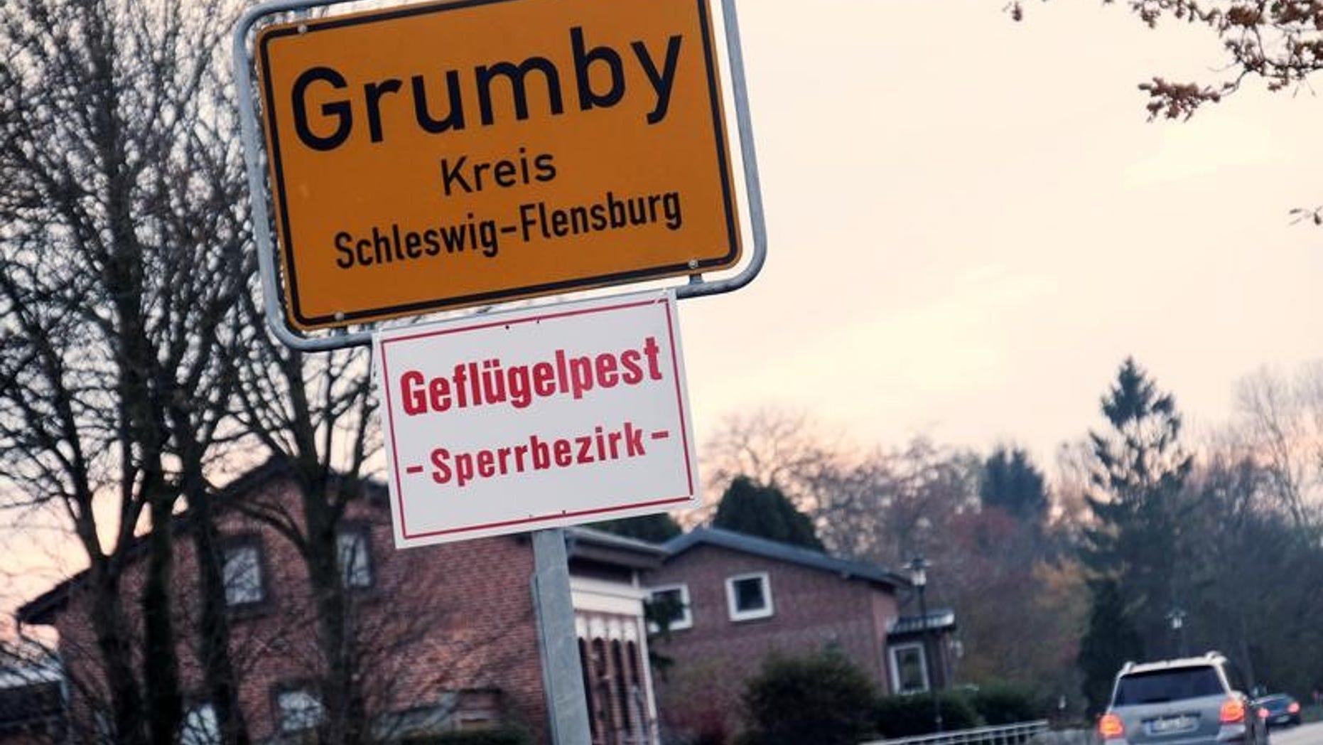 A car drives past the town sign in the northern German village of Grumby