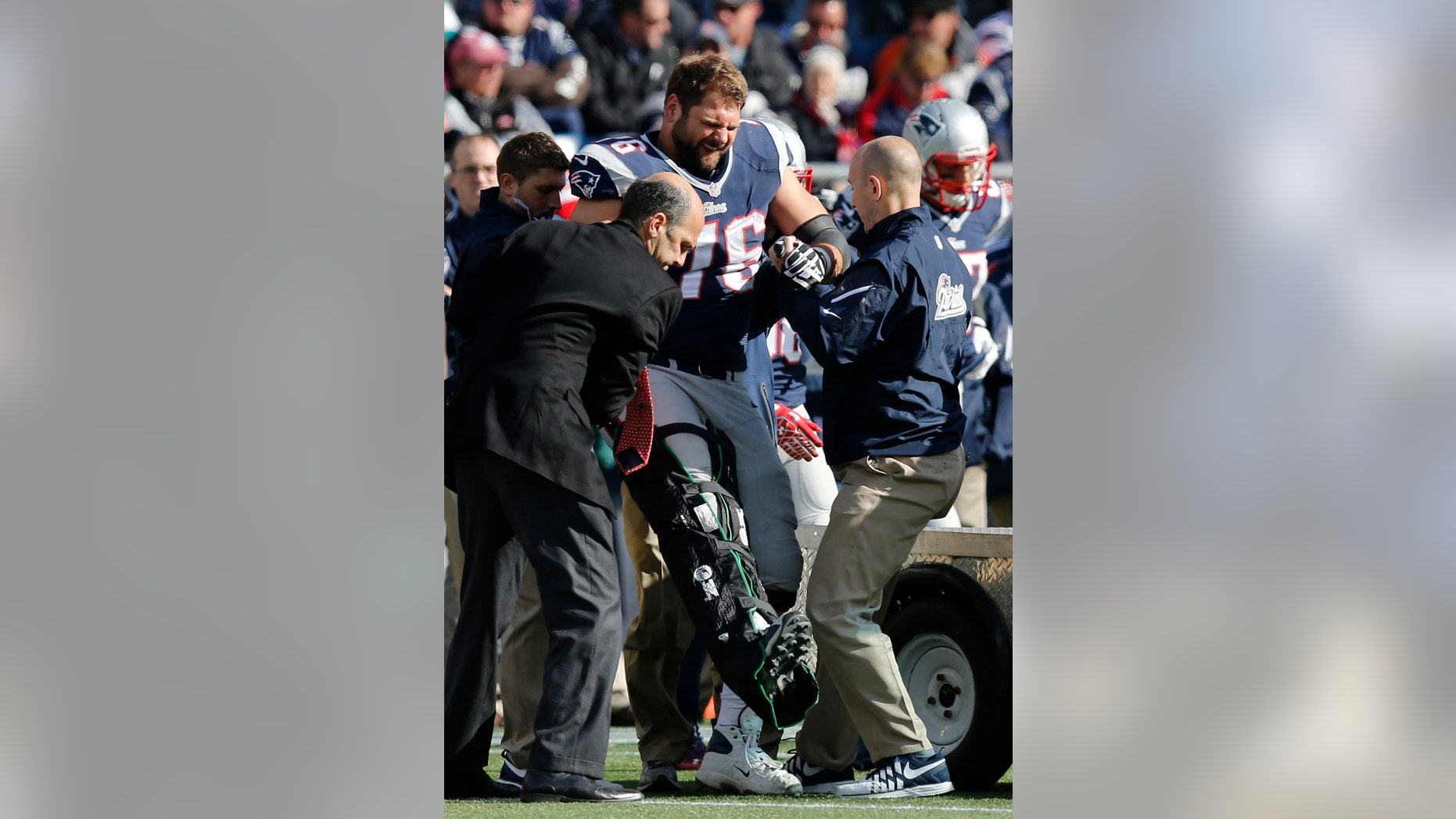 New England Patriots tackle Sebastian Vollmer is tended after an injury in the second quarter of an NFL football game against the Miami Dolphins on Sunday, Oct. 27, 2013, in Foxborough, Mass. (AP Photo/Michael Dwyer)