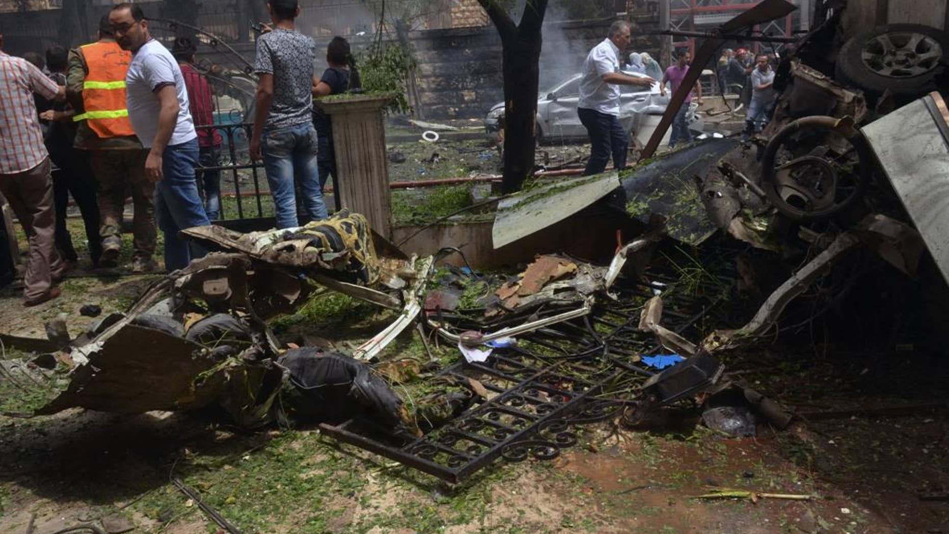 FILE - In this Tuesday, May 3, 2016, file photo released by the Syrian official news agency SANA, Syrian citizens and firefighters gather at the scene where one of rockets hit the Dubeet hospital in the central neighborhood of Muhafaza in Aleppo, Syria. A fragile cease-fire in the northern Syrian city of Aleppo has been extended for 72 hours, Russia said, as the Islamic State group battled other militant factions near the city on Saturday. (SANA via AP)