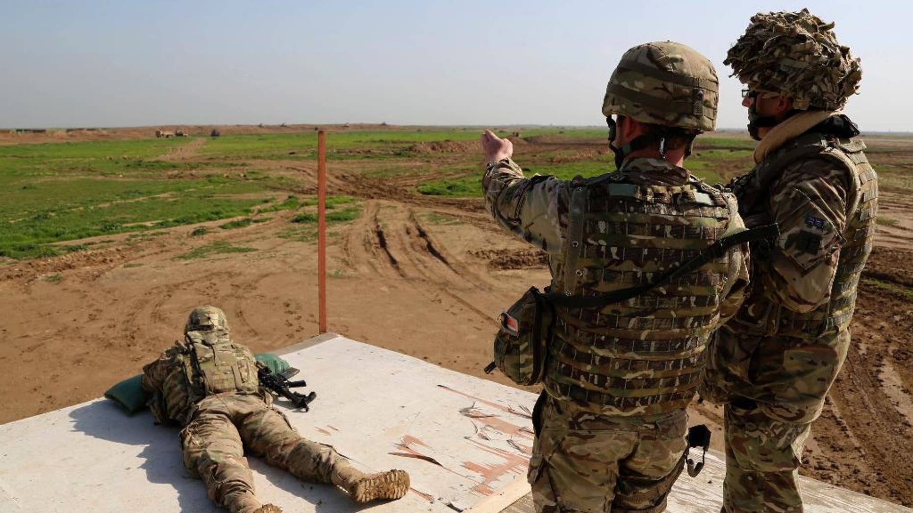 FILE - In this Jan. 24, 2016, file photo, American and Spanish trainers use live ammunition in training exercises at Basmaya base, 40 kilometers southeast of Baghdad, Iraq. Intelligence assessments approved by senior leaders at U.S. Central Command exaggerated the progress of anti-terrorism efforts they ran against Islamic State militants, a House Republican task force said in an initial report released Aug. 11. (AP Photo/Karim Kadim, File)