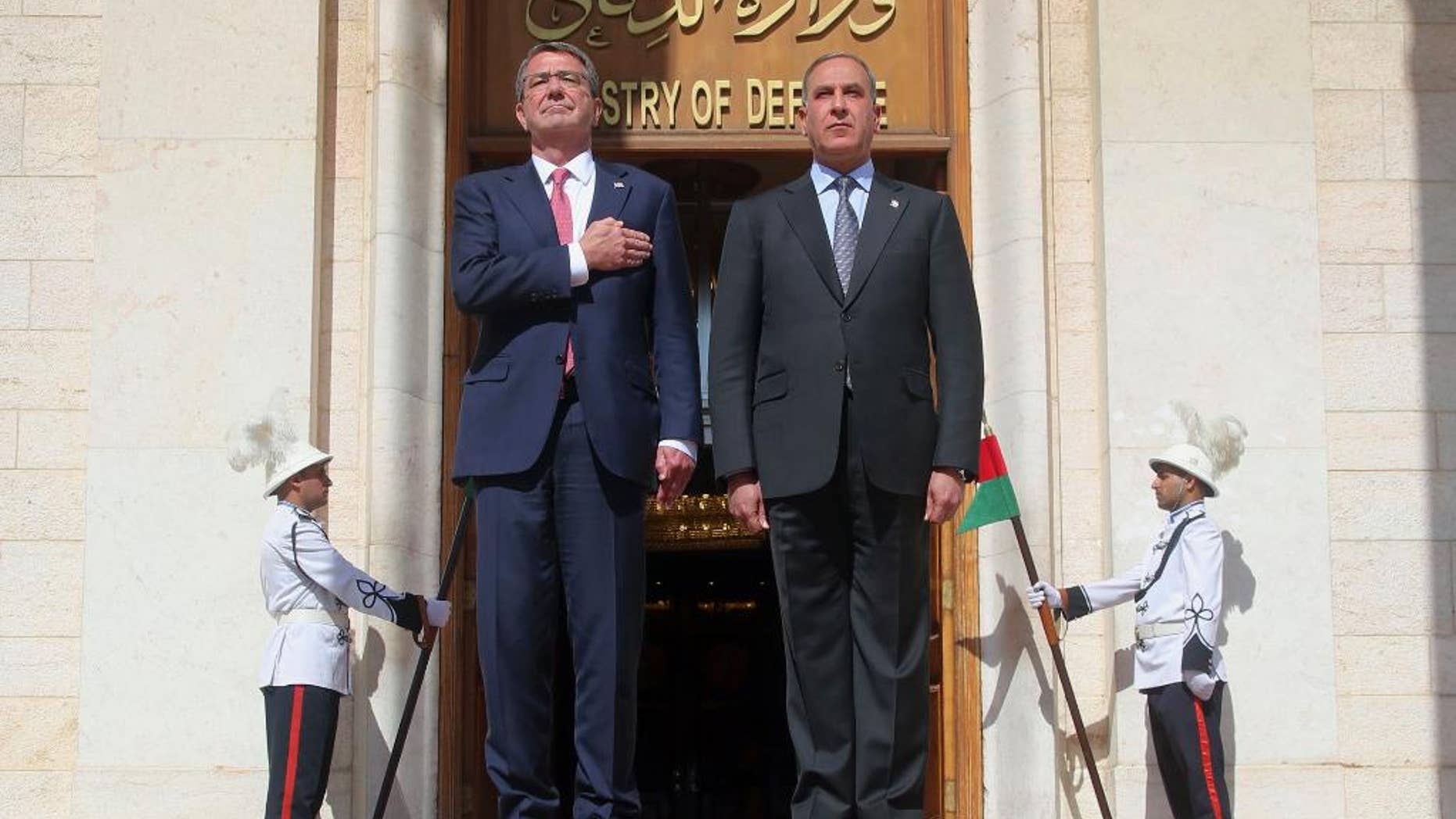 FILE - In this Monday, April 18, 2016 file photo, visiting U.S. Defense Secretary Ash Carter, left, and his Iraqi counterpart, Khaled al-Obeidi, stand for their country's national anthems during a welcome ceremony at the Ministry of Defense in Baghdad, Iraq. On Saturday, Dec. 3, 2016, Carter said the American military, along with its international partners, will need to remain in Iraq even after the expected defeat of the Islamic State group. (AP Photo)