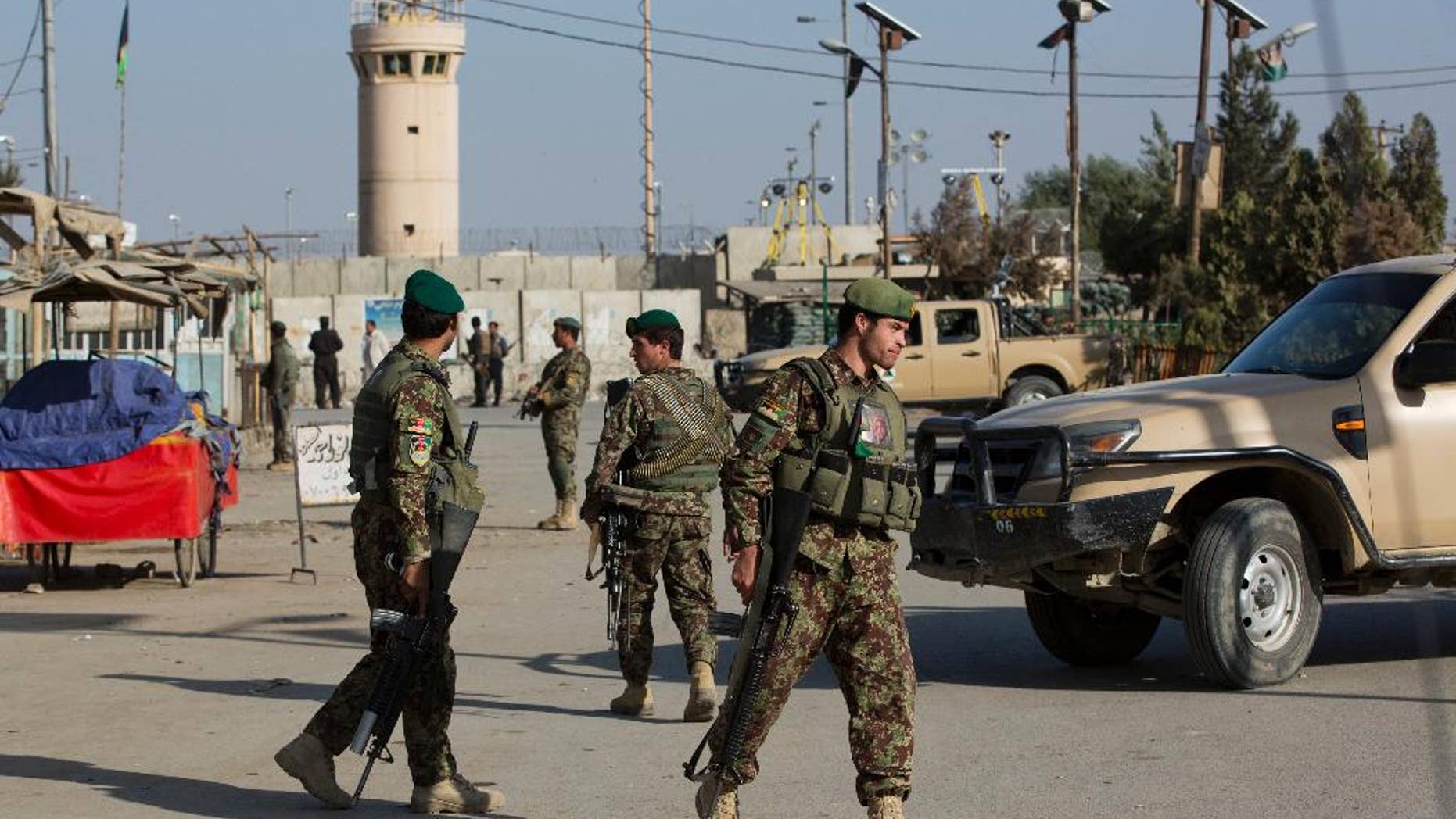Afghanistan's National Army soldiers guard, blocking the main road to the Bagram Airfield's main gate in Bagram, north of Kabul, Afghanistan, Saturday, Nov. 12, 2016. An explosion at a U.S. airfield in Afghanistan early Saturday killed four people, the head of international forces in the country said. (AP Photos/Massoud Hossaini)