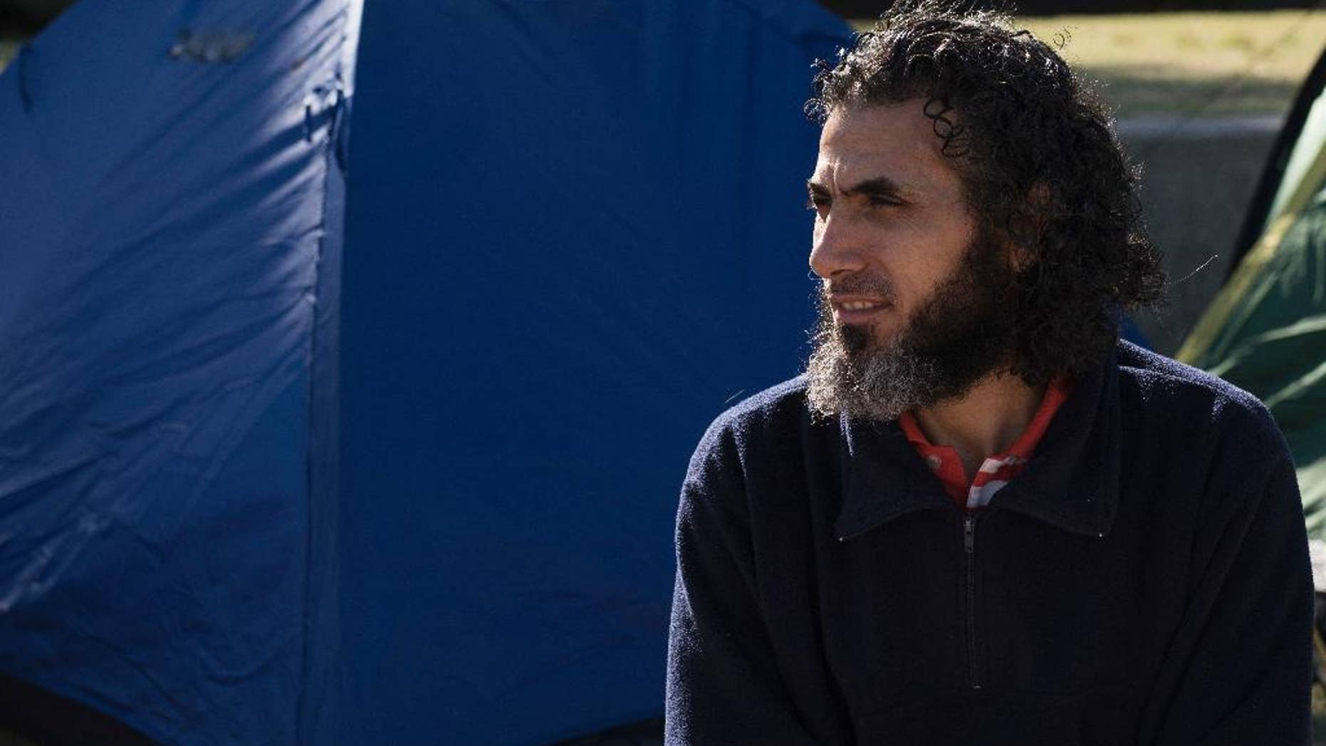 FILE - In this May 5, 2015 file photo, Abu Wa'el Dhiab, from Syria, sits in front of the U.S. embassy while visiting former fellow detainees demanding financial assistance from the U.S., in Montevideo, Uruguay. Ending a two-year struggle to leave Uruguay, former Guantanamo detainee Abu Wa'el Dhiab left the South American country on Thursday, Dec. 15, for Johannesburg, South Africa, said Christian Mirza, Dhiab's former government liaison. (AP Photo/Matilde Campodonico, File)