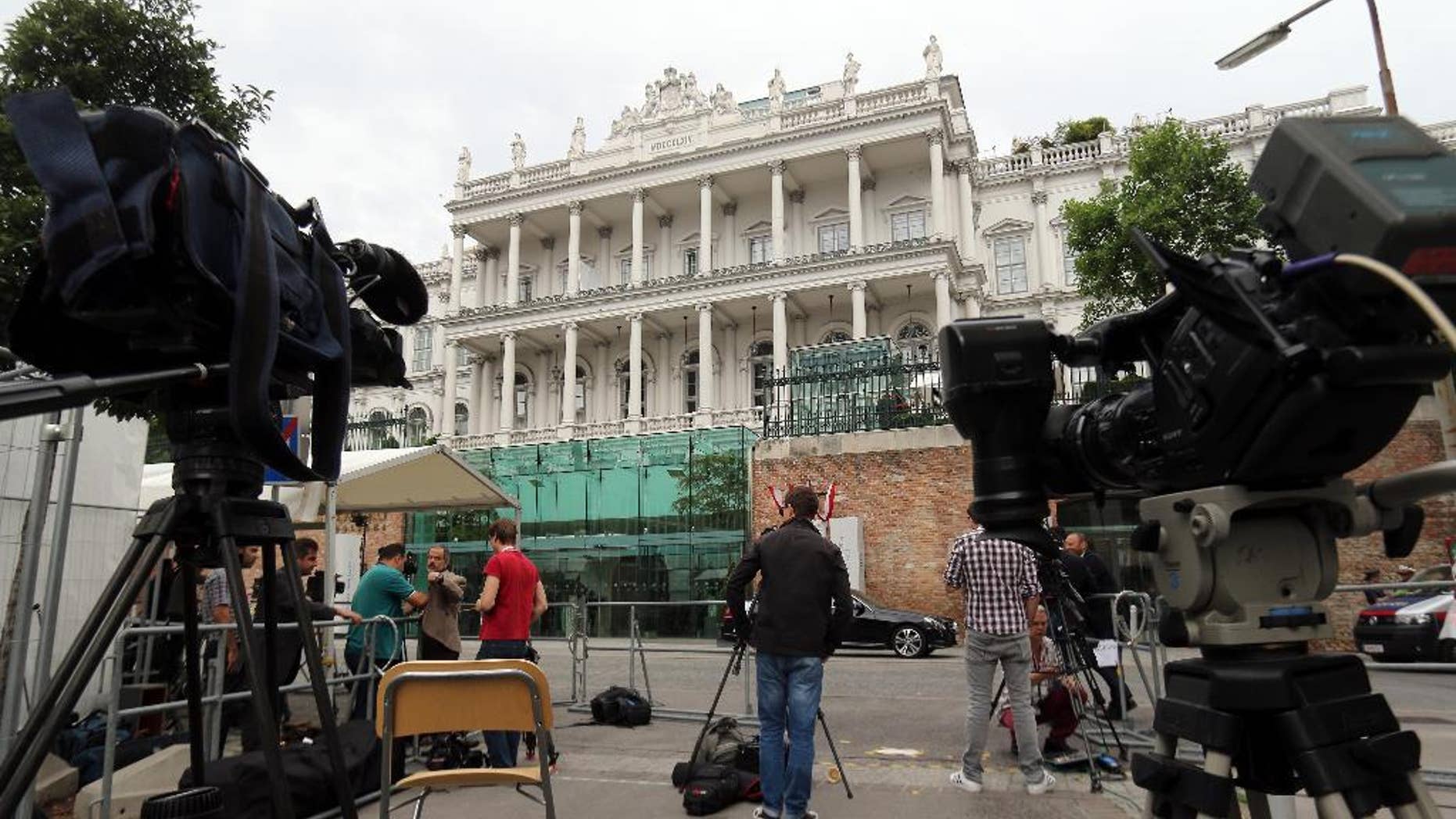 Journalists and journalists are waiting in front of Palais Coburg where closed-door nuclear talks with Iran take place in Vienna, Austria, Monday, June 29, 2015. (AP Photo/Ronald Zak)