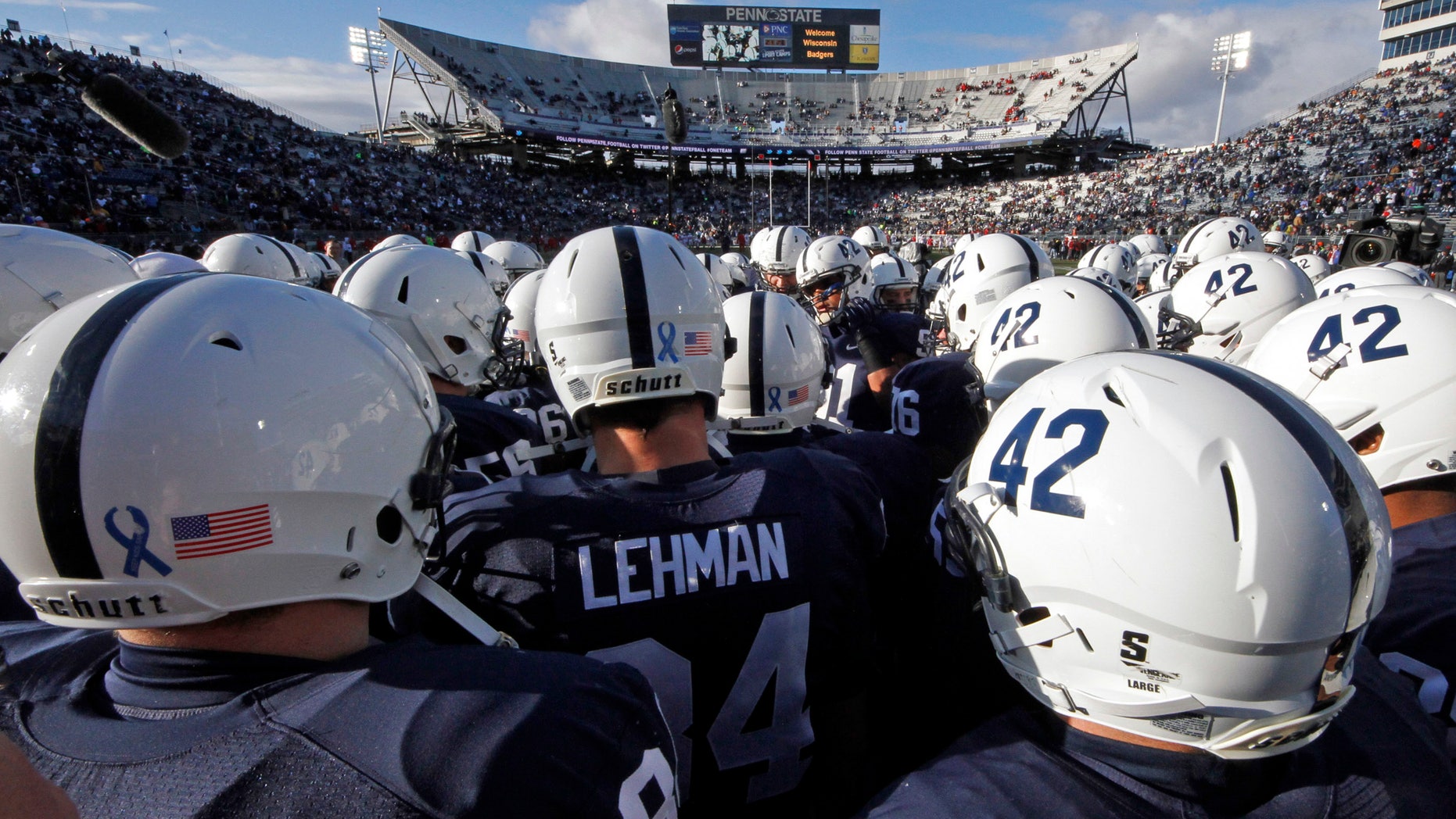 FILE - In this Nov. 24, 2012, file photo Penn State players huddle on the field before an NCAA college football game against Wisconsin in State College, Pa. Penn State said about 90 percent of the $7.8 million decline in revenue for the athletic department was due to a loss of one-time fees related to football season-ticket renewals that were not budgeted for in 2012. (AP Photo/Gene J. Puskar, File)