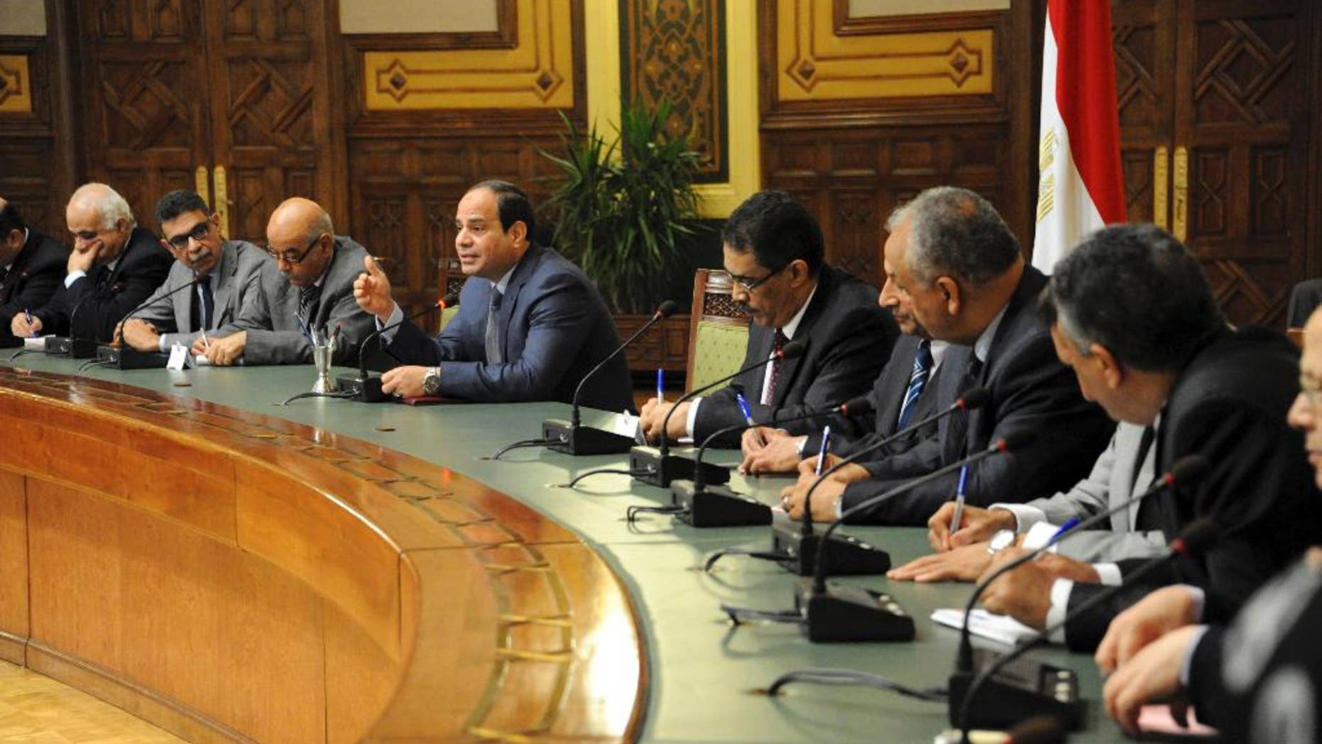 In this photo provided by Egypt's state news agency MENA, Egyptian President Abdel-Fattah el-Sissi, center, meets with editors of Egyptian newspapers and media in the presidential palace, in Cairo Egypt, Sunday, Aug. 24, 2014. El-Sissi denied Sunday any military involvement in neighboring Libya, a day after Islamist militias accused Cairo of bombing their posts in Tripoli, Egypt's state news agency reported. El-Sissi said Egypt is in consultation with Libya's neighbors to find a political solution to the violent power struggle between rival groups. (AP Photo/MENA)