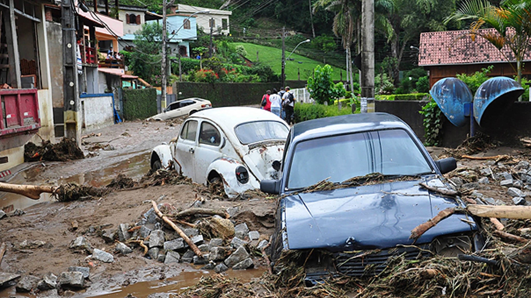 Jan. 12: Cars sit in debris in a flooded street in Teresopolis, Rio de Janeiro state, Brazil.