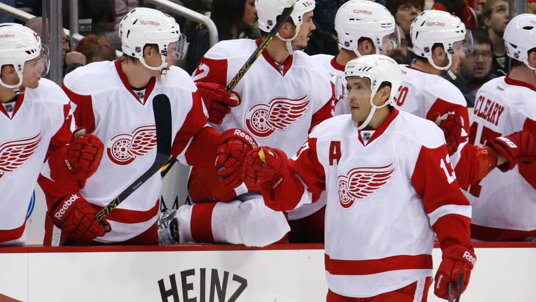 Detroit Red Wings' Pavel Datsyuk (13) celebrates with teammates as he returns to the bench after scoring during the second period of a NHL pre-season hockey game against the Pittsburgh Penguins in Pittsburgh Monday, Sept. 22, 2014. (AP Photo/Gene J. Puskar)