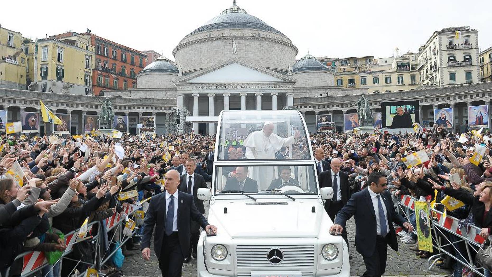 In this March 21, 2015 pool photo, made available Monday, March 23, 2015, Pope Francis, center, is cheered by faithful as he arrives with his popemobile to celebrate a Mass, in Naples, Italy. Pope Francis made an impassioned defense of the unemployed during a speech to people in the poor Neapolitan neighborhood of Scampia Saturday. (AP Photo/L'Osservatore Romano, Pool)