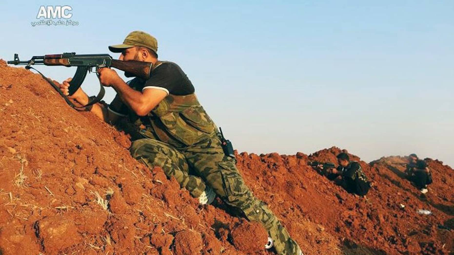 Sunday, Aug. 17, 2014: This photo provided by the anti-government activist group Aleppo Media Center (AMC), which has been authenticated based on its contents and other AP reporting, shows a Free Syrian Army fighter aiming his weapon during a battle with Islamic State militants in Aleppo, Syria.