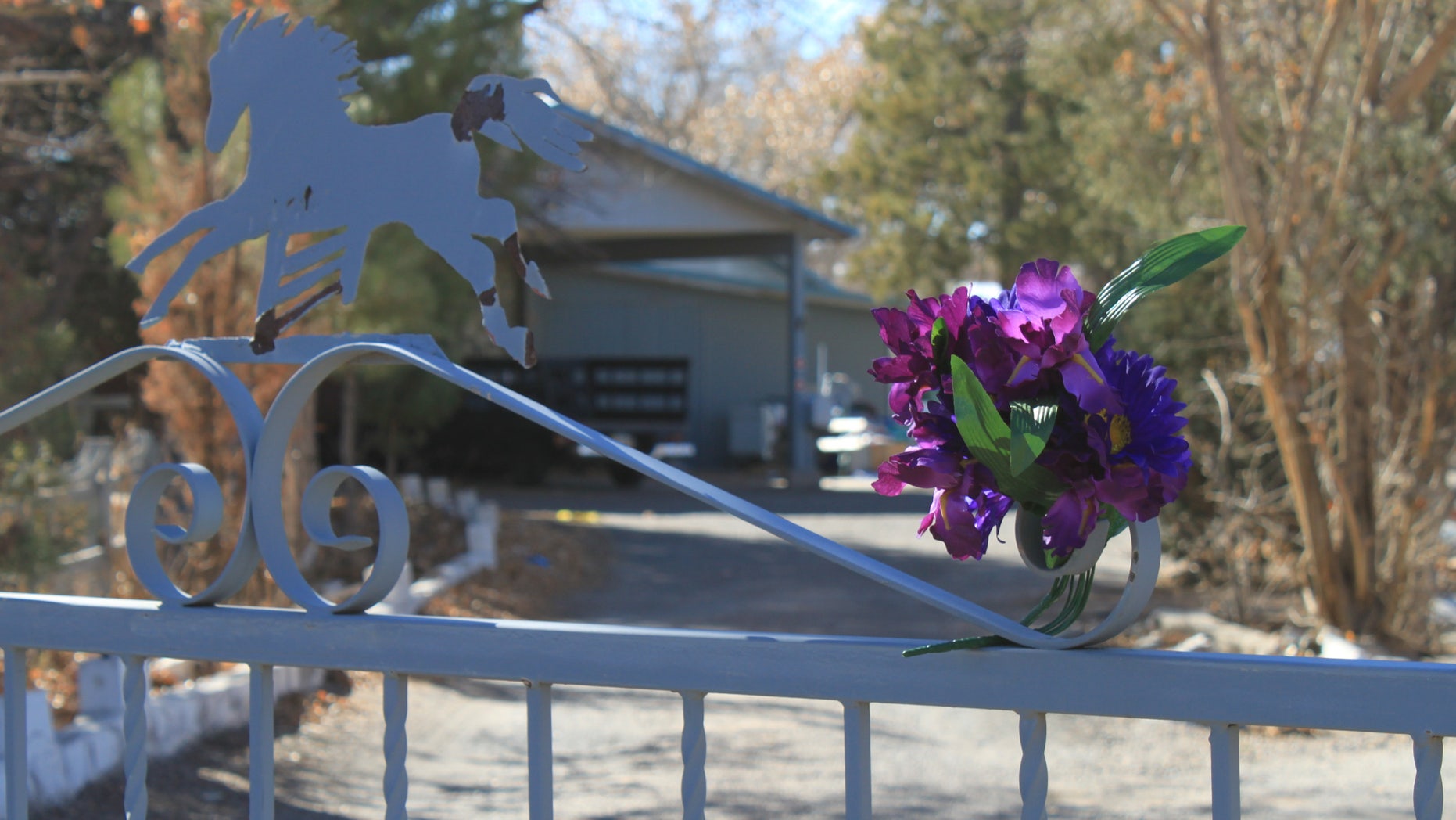 A bouquet of flowers adorns the entrance to a home on Monday, Jan. 21, 2013, where a couple and their three young children were found shot to death south of Albuquerque, N.M. The couple's 15-year-old son, Nehemiah Griego, is facing counts of murder and child abuse in connection with the shootings. (AP Photo/Susan Montoya Bryan)