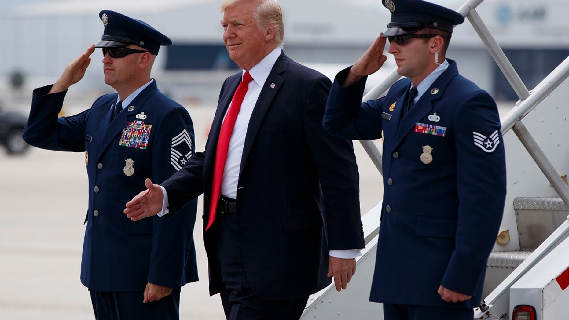 President Donald Trump smiles upon his arrival on Air Force One at Miami International Airport in Miami, Friday, June 16, 2017, before speaking on Cuba policy. (AP Photo/Evan Vucci)