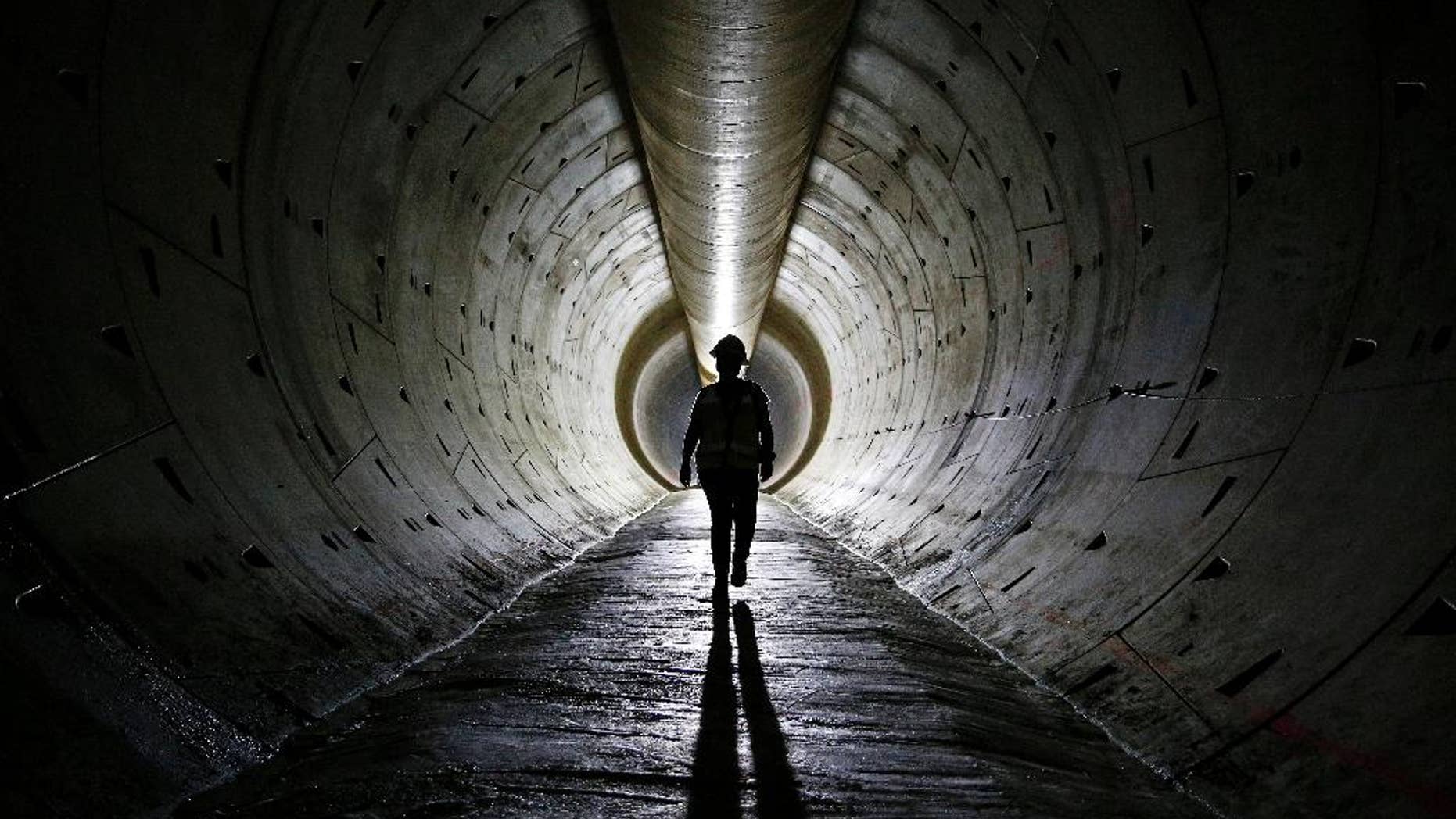 FILE - In this June 1, 2015, file photo, Robin Rockey, of the Southern Nevada Water Authority, walks through a tunnel still under construction beneath Lake Mead near Boulder City, Nev. The Conference Board reports on its index of leading economic indicators for June on Thursday, July 23, 2015. (AP Photo/John Locher, File)
