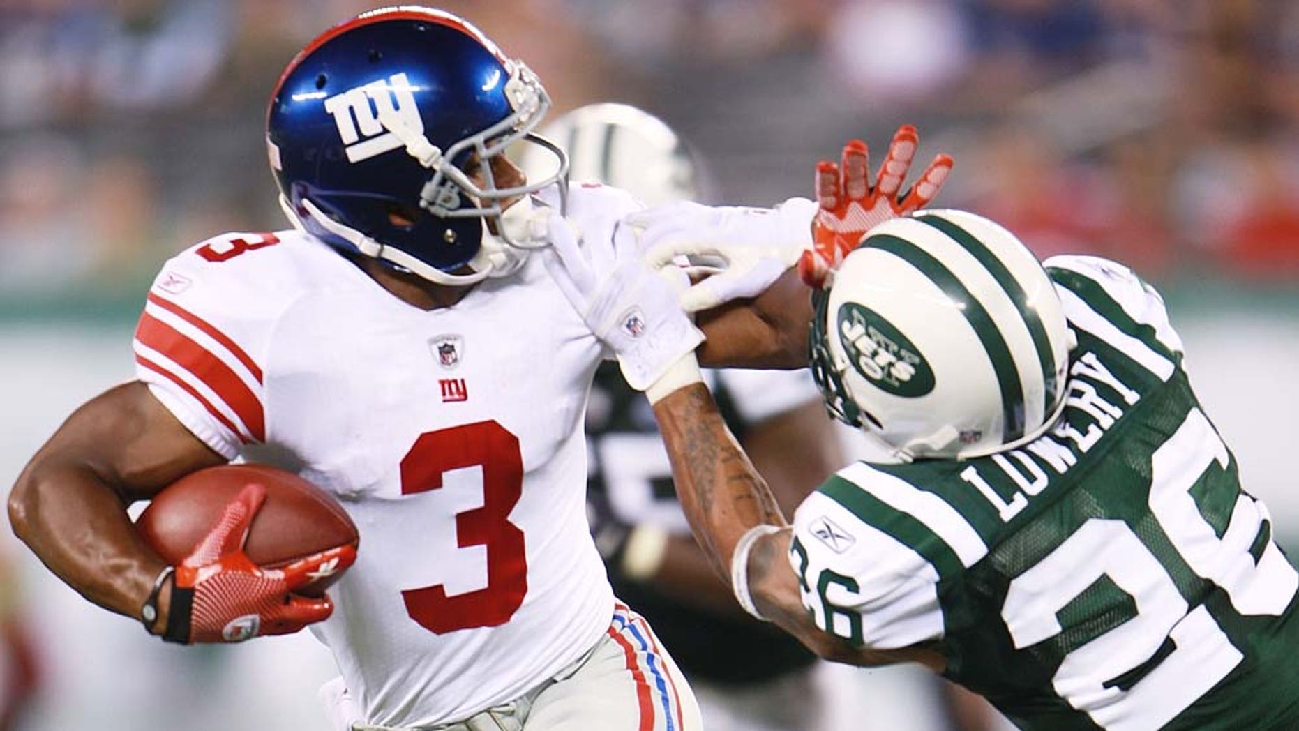 New York Giants Victor Cruz fights off Jets defender.