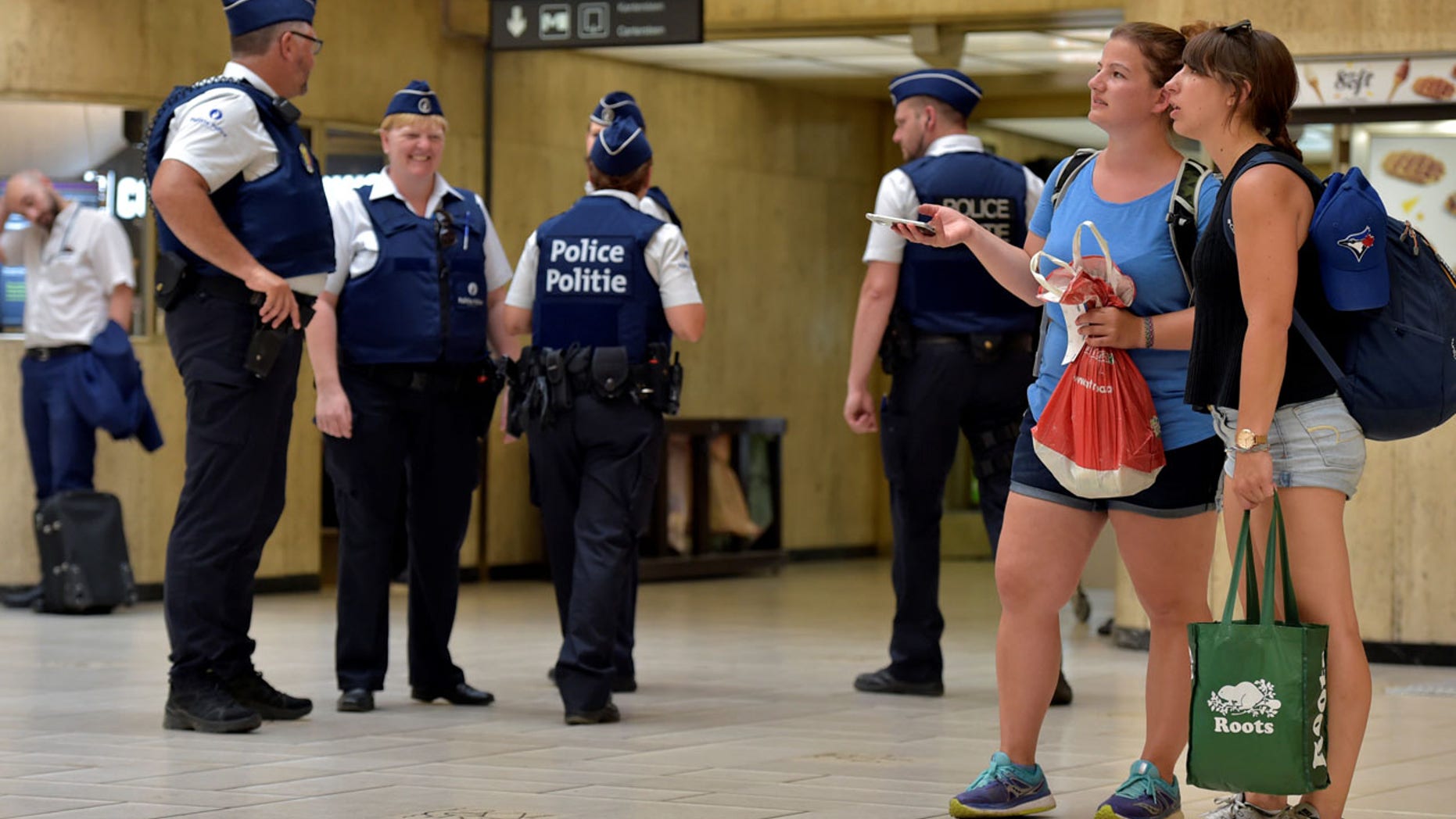 Belgian police officers stand guard in central station in Brussels, Belgium