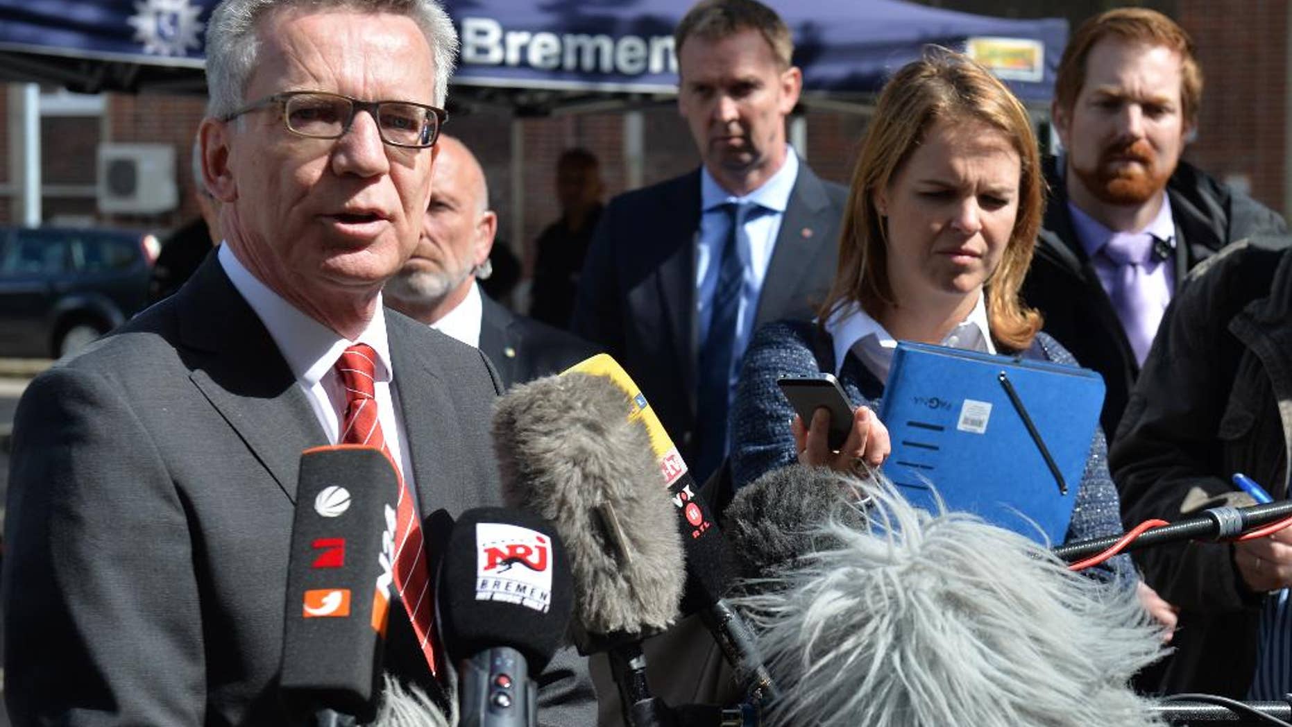 German Interior Minister Thomas de Maiziere, left, speaks to the media during his visit to Bremen, northern Germany, Wednesday, Aug. 10, 2016. ( Carmen Jaspersen/dpa via AP)