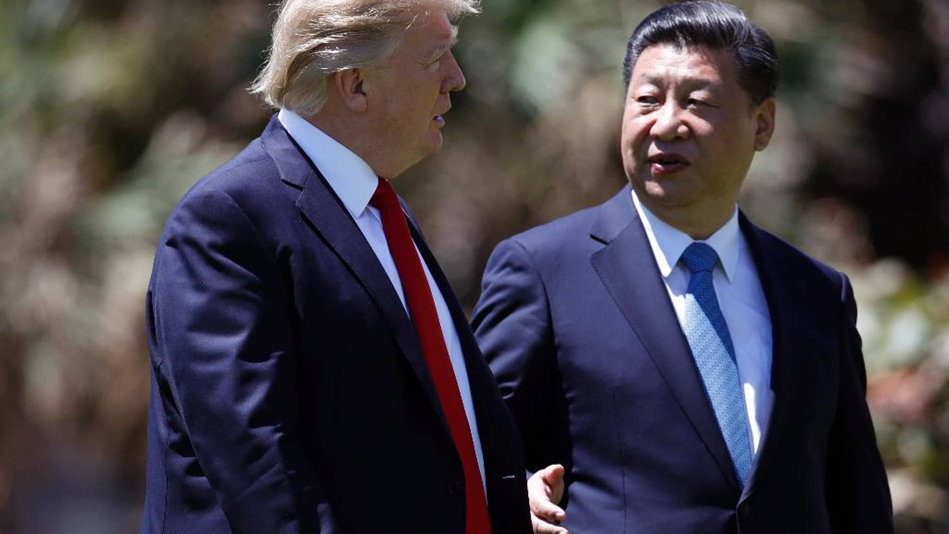 FILE - In this April 7, 2017 file photo, President Donald Trump, left, and Chinese President Xi Jinping walk together after their meetings at Mar-a-Lago, in Palm Beach, Fla. Trump has praised Xi since hosting him at his Palm Beach, Fla., resort, after sharply criticizing China’s economic policies as a candidate. Since taking office, Trump has displayed a striking willingness to embrace autocrats as potential partners in his “America First” agenda, even if it means ignoring their heavy-handed tactics and repression at home. (AP Photo/Alex Brandon, File)