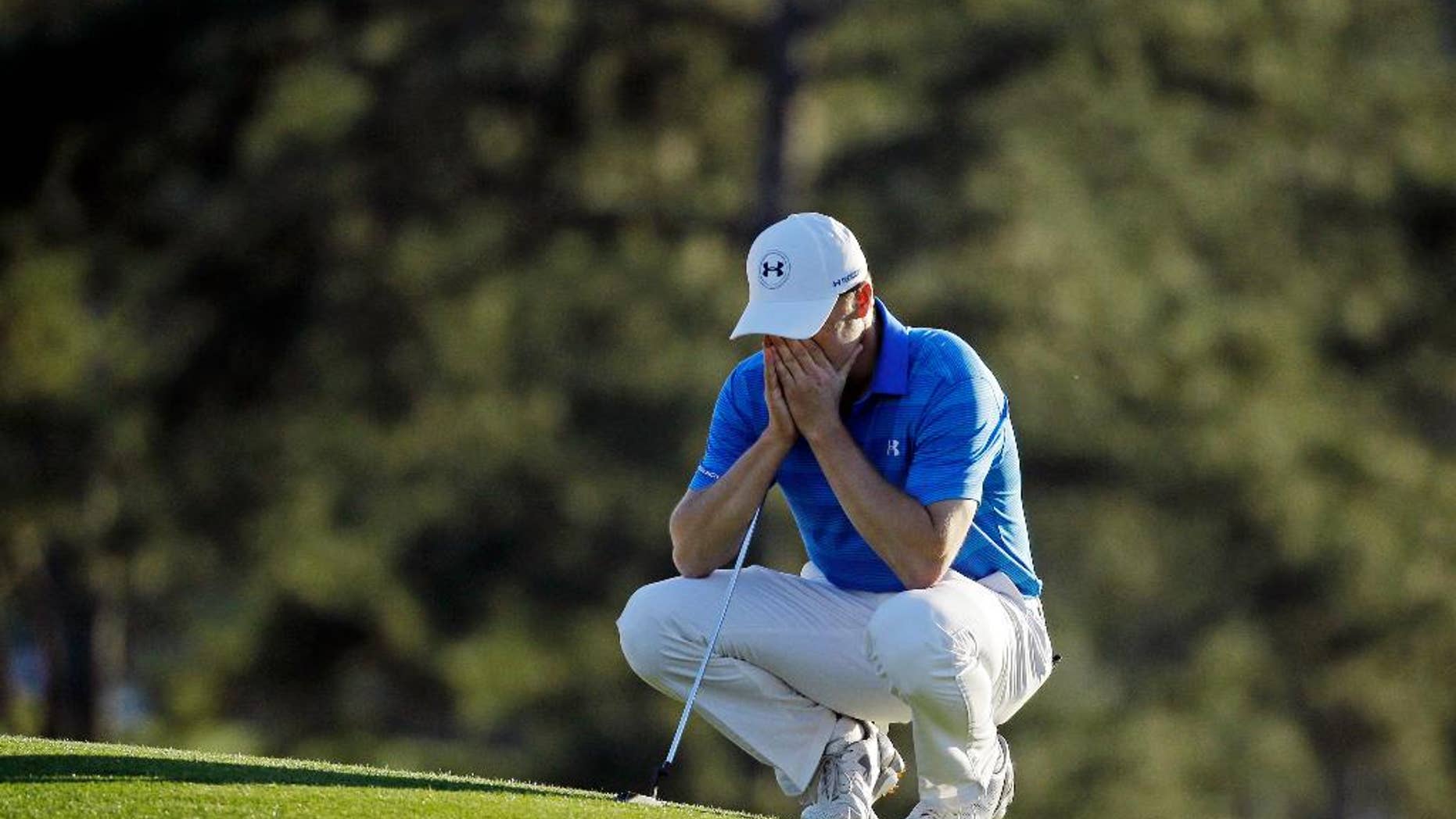 Jordan Spieth pauses on the 18th green before putting out during the final round of the Masters golf tournament Sunday, April 10, 2016, in Augusta, Ga. (AP Photo/Chris Carlson)