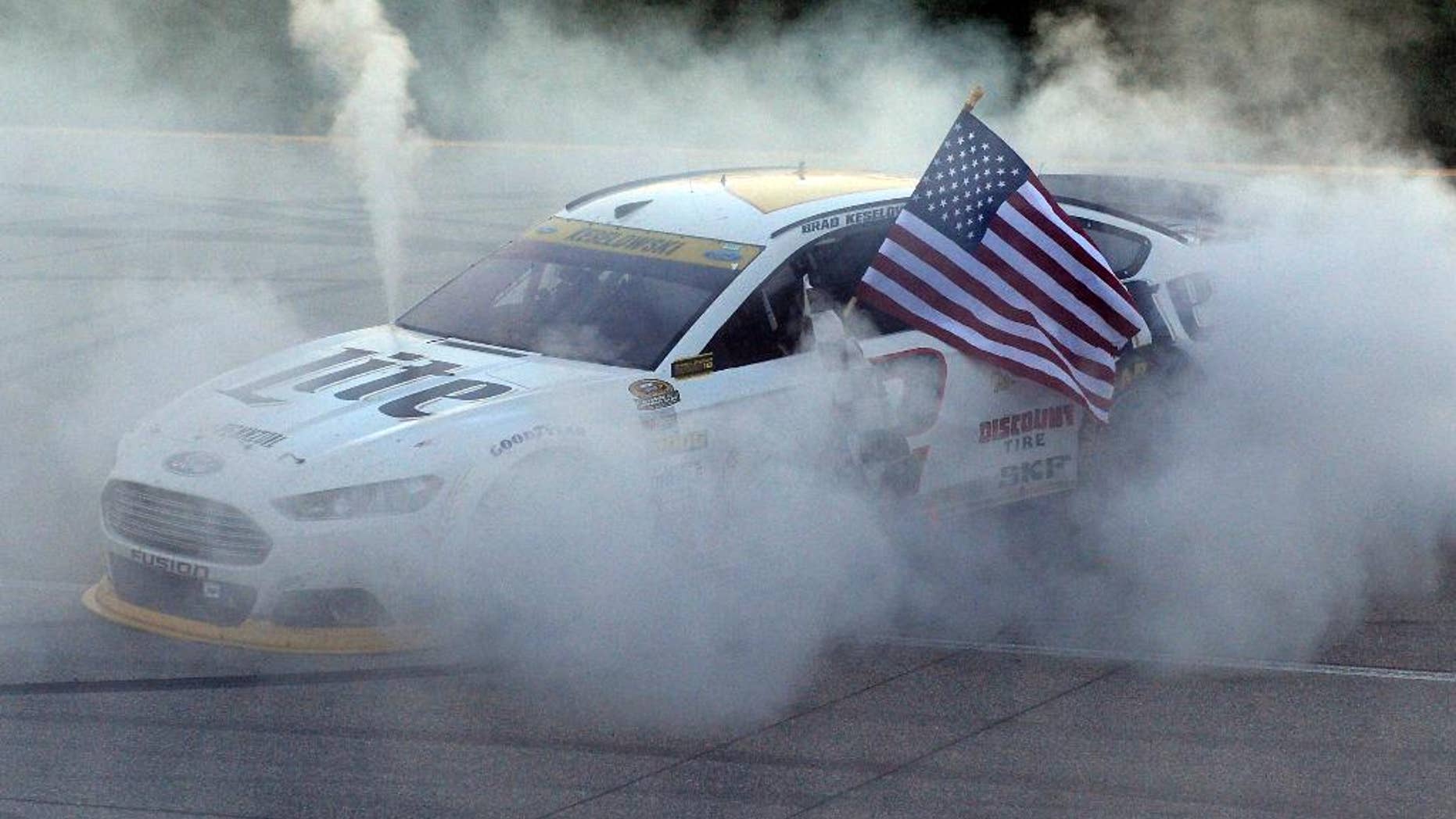 Brad Keselowski (2) celebrates his win with a burnout after winning the NASCAR Sprint Cup series auto race at Chicagoland Speedway in Joliet, Ill., Sunday, Sept. 14, 2014. (AP Photo/Paul J. Bergstrom)