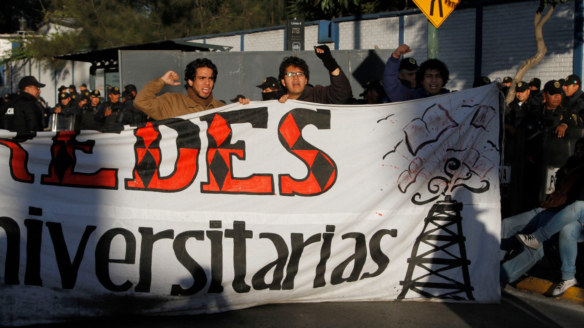 Demonstrators shout slogans against political reforms in front of riot police guarding outside at the National Congress in protest against the newly approved energy reform bill in Mexico City, Thursday, Dec. 12, 2013. Mexico's Senate, in the early hours of Wednesday approved the most dramatic oil reform in decades, moving the country closer to opening its state-run sector to private companies and investment. With the Senate passage, the bill also must be approved by the lower house and by the legislatures of 17 of Mexico's 31 states and Federal District. (AP Photo/Marco Ugarte)