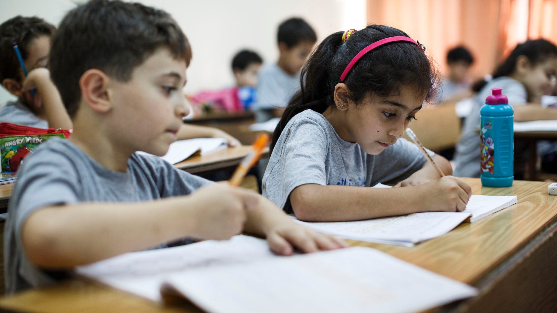 RAMALLAH, WEST BANK - SEPTEMBER 17: Palestinian children take notes in their notebooks during a math class on September 17, 2013 in Ramallah, West Bank. The West Bank is a landlocked territory which has an estimated population of 2, 622,544 with Arabs making up almost 80% of the population. It is a disputed territory after Israel captured the land during the six day war in 1967. (Photo by Ilia Yefimovich/Getty Images)