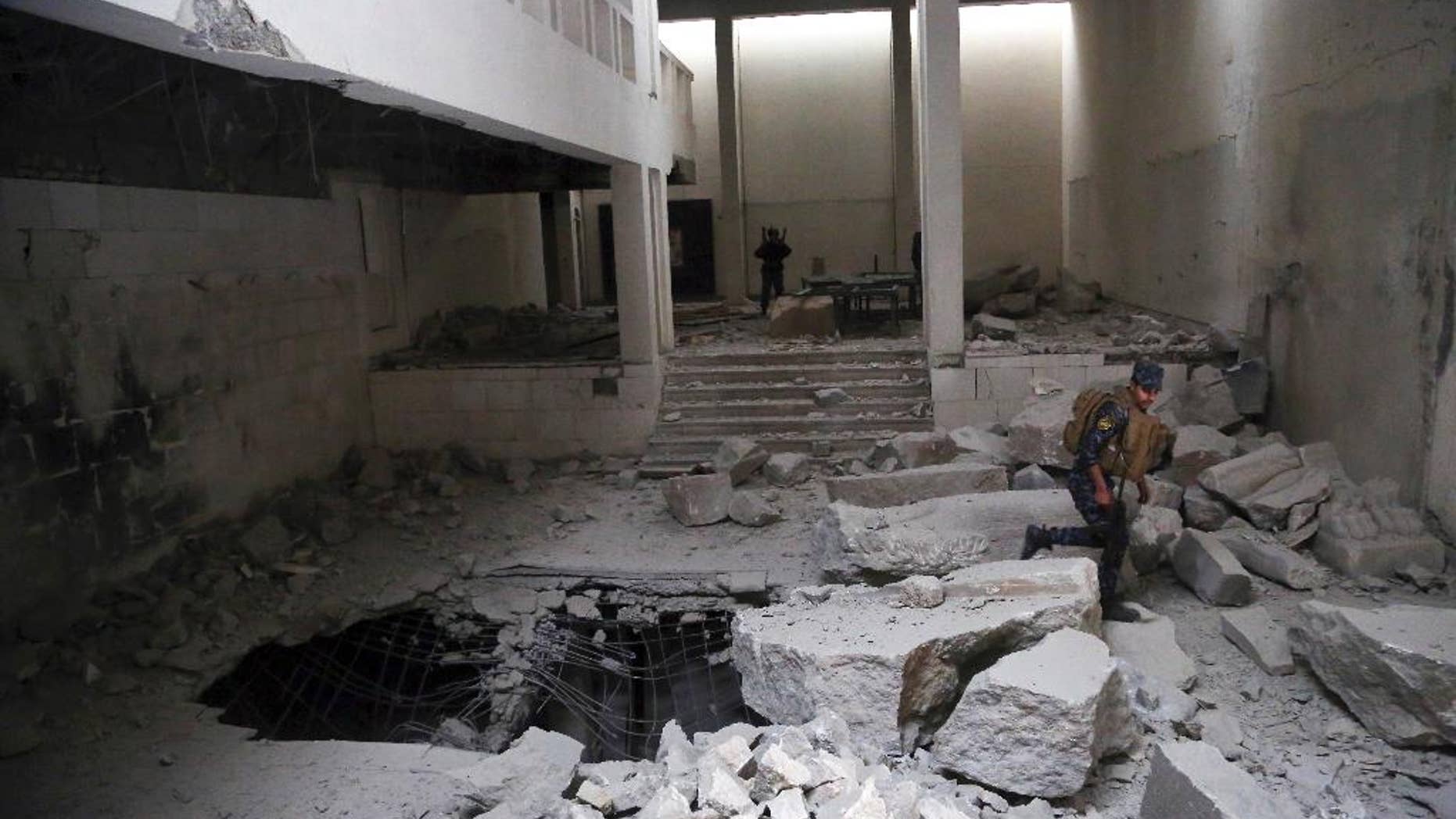 Iraqi police inspect Mosul's damaged museum.