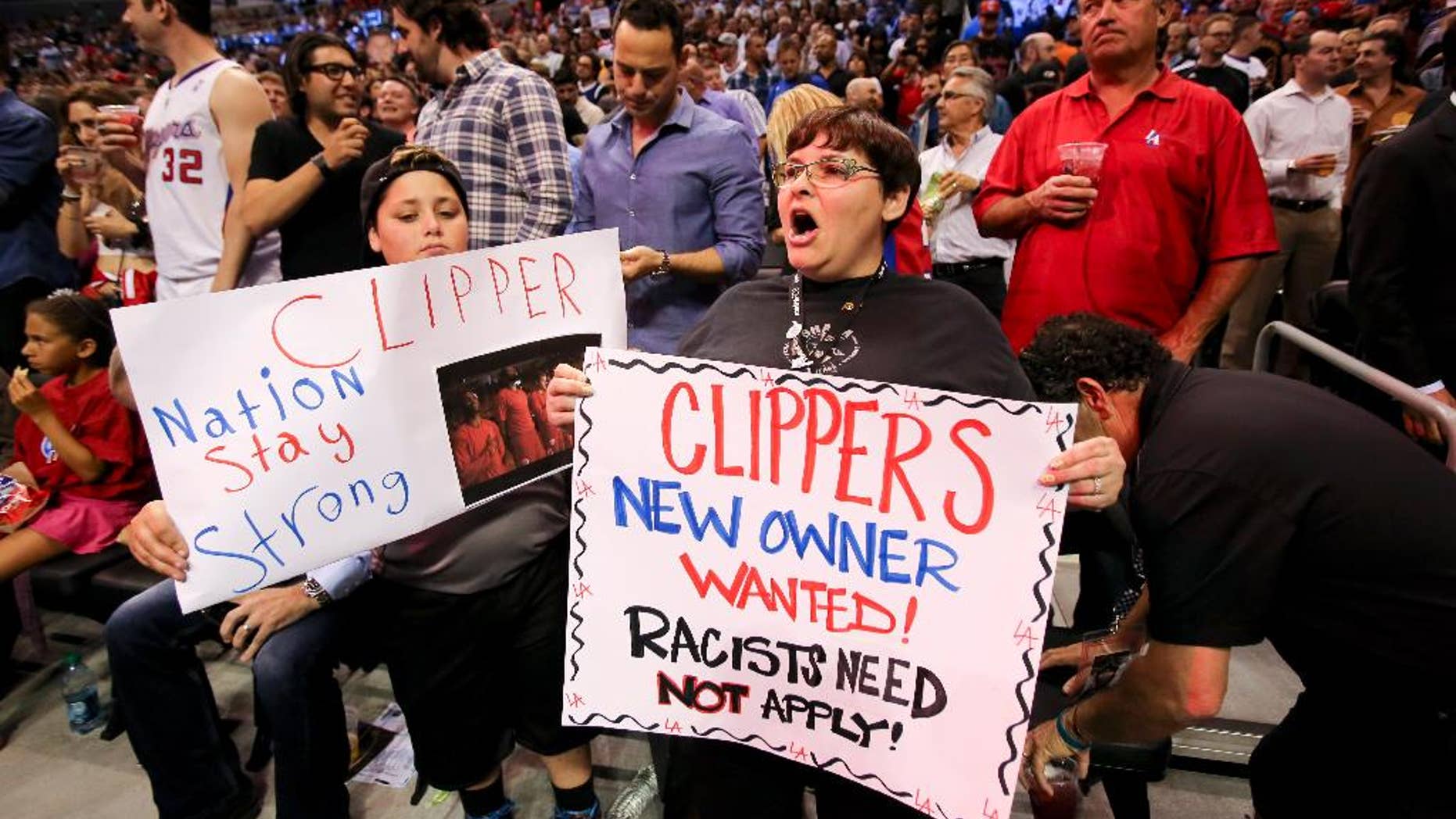 Fans hold up signs in support of the Los Angeles Clippers before Game 5 of an opening-round NBA basketball playoff series between the Clippers and the Golden State Warriors on Tuesday, April 29, 2014, in Los Angeles. NBA Commissioner Adam Silver announced Tuesday that Clippers owner Donald Sterling has been banned for life by the league. (AP Photo/Ringo H.W. Chiu)