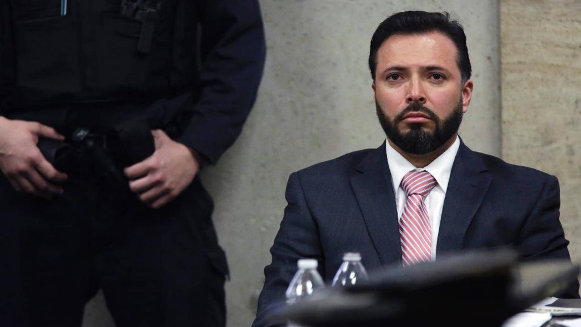 FILE - In this April 20, 2015, file photo, Chicago Police Detective Dante Servin listens as Judge Dennis Porter reads his decision at the Leighton Criminal Court Building in Chicago on involuntary manslaughter charges in the March 2012 shooting death of Rekia Boyd. Servin, whom the department was trying to fire after he fatally shot Boyd, has decided to resign from the force rather than fight to retain his job. (John J. Kim/Chicago Tribune via AP, Pool)