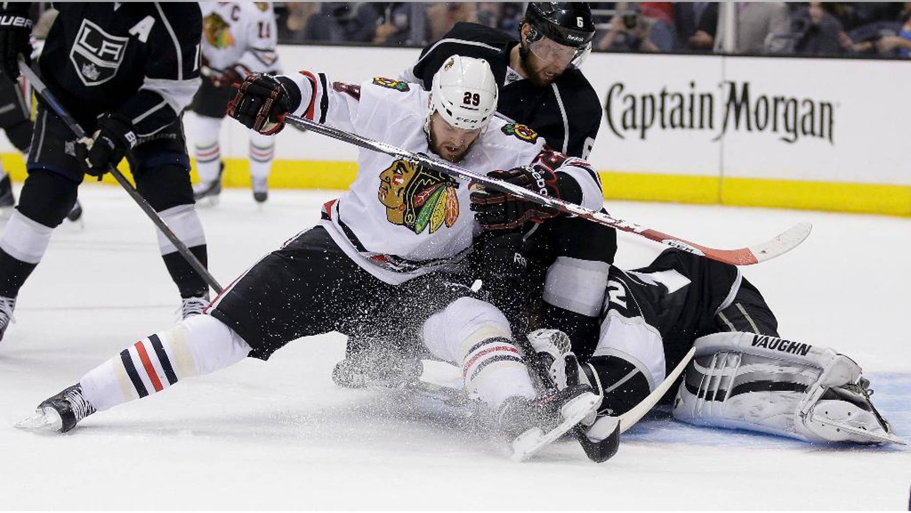 Los Angeles Kings goalie Jonathan Quick, right, blocks a shot by Chicago Blackhawks left wing Bryan Bickell as Kings' Jake Muzzin helps defend during first period of Game 6 of the Western Conference finals of the NHL hockey Stanley Cup playoffs, in Los Angeles on Friday, May 30, 2014. (AP Photo/Chris Carlson)