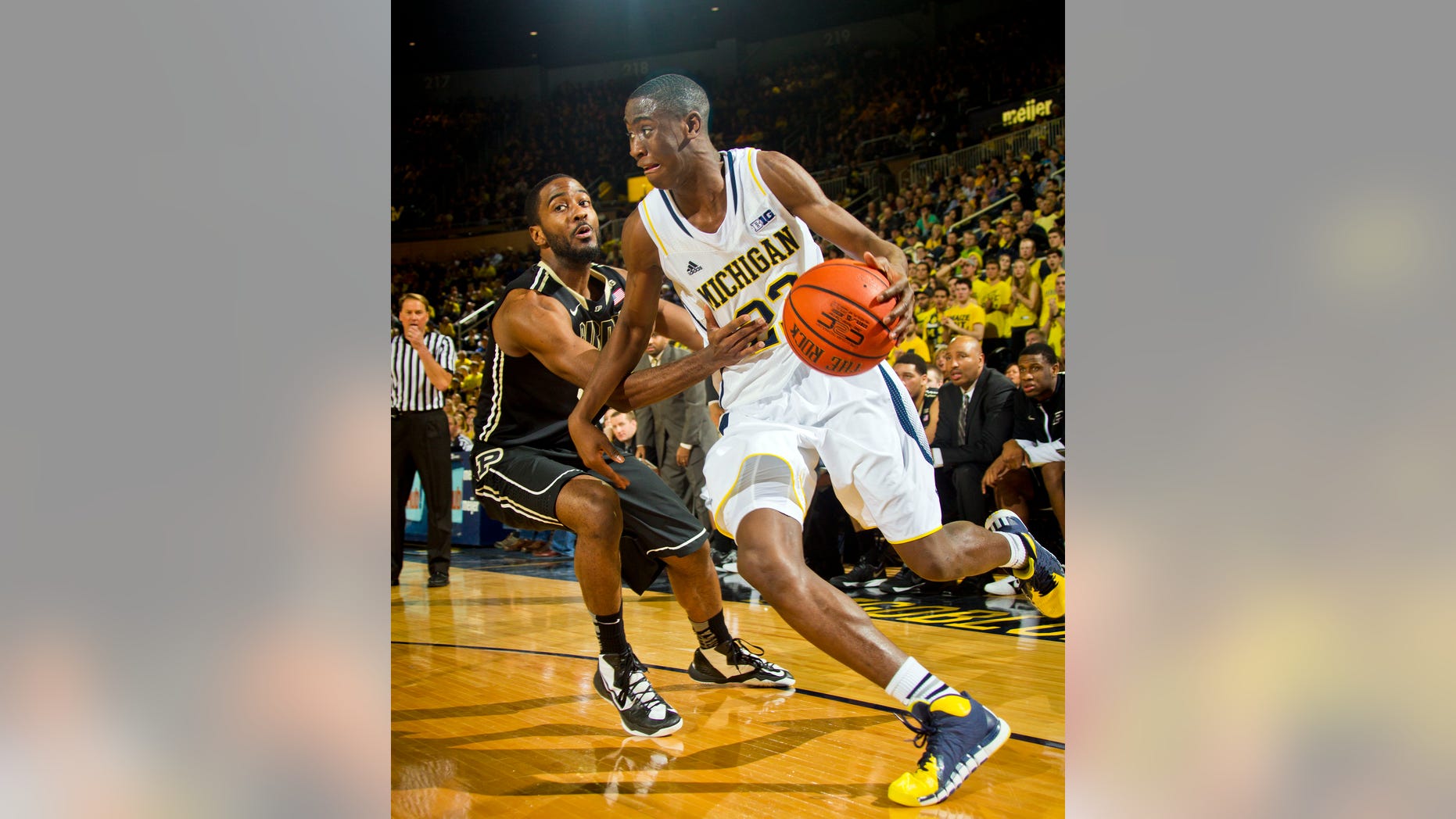 Purdue guard Rapheal Davis, left, defends Michigan guard Caris LeVert (23) in the first half of an NCAA college basketball game in Ann Arbor, Mich., Thursday, Jan. 30, 2014. (AP Photo/Tony Ding)