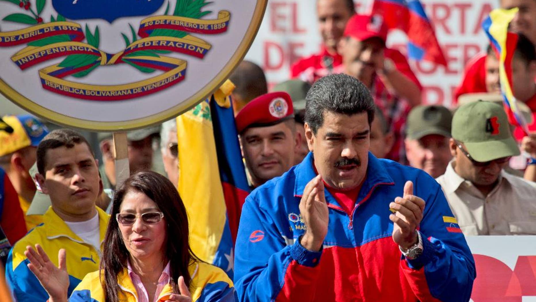 Venezuela's President Nicolas Maduro, right, and his wife Cilia Flores greet supporters during a rally outside of Miraflores presidential palace in Caracas, Venezuela, Saturday, Feb. 28, 2015. Venezuelans took to the streets of Caracas in dueling demonstrations on Saturday, with one group calling attention to a crackdown on opponents of the government and another showing support for the embattled socialist administration. T (AP Photo/Fernando Llano)