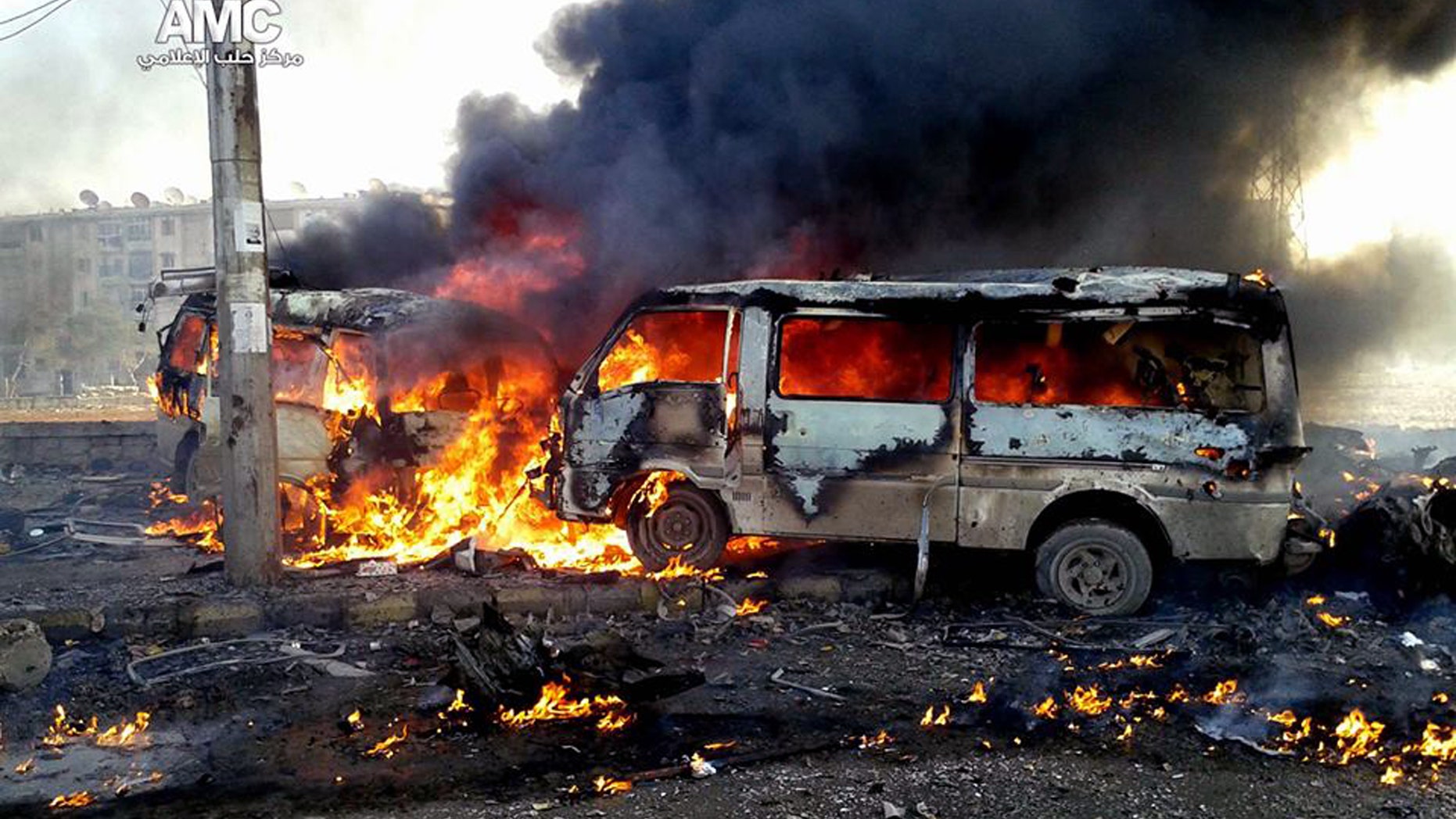 This Sunday, Dec. 15, 2013 citizen journalism image provided by Aleppo Media Center AMC, which has been authenticated based on its contents and other AP reporting, shows flames rising from burning vehicles following a Syrian government airstrike in Aleppo, Syria. The Britain based Syrian Observatory for Human Rights said Monday that dozens of children were among the scores killed in airstrikes on several opposition areas a day earlier. (AP Photo/Aleppo Media Center, AMC)