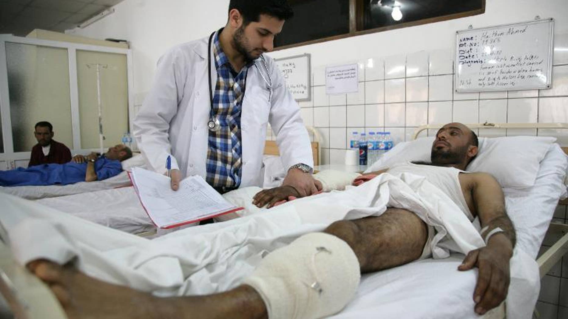 A doctor checks on a wounded man in hospital in Arbil on April 25, 2013
